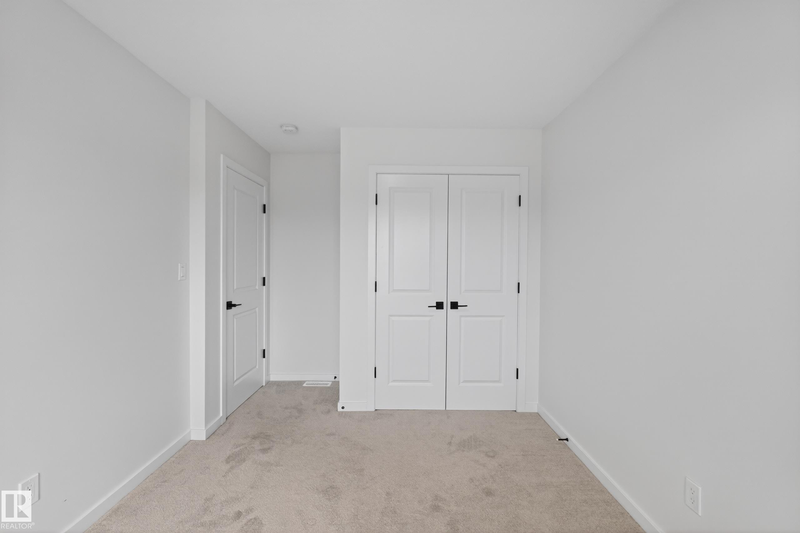 Neutral tone walls with white trim, carpeting, and matte black door hardware - 17023 45 Street, Edmonton, AB