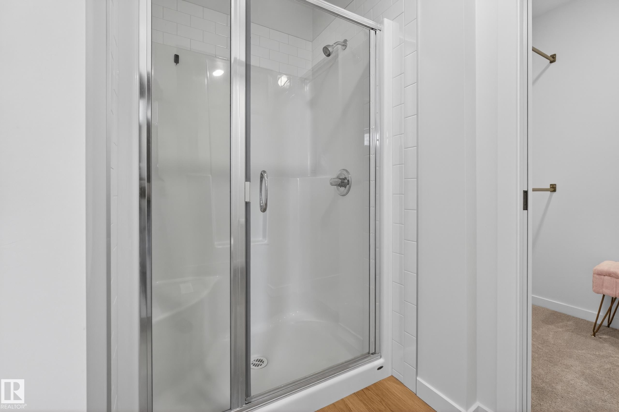 Enclosed shower with clear glass sliding door, polished chrome hardware, and white subway tile surround - 17023 45 Street, Edmonton, AB