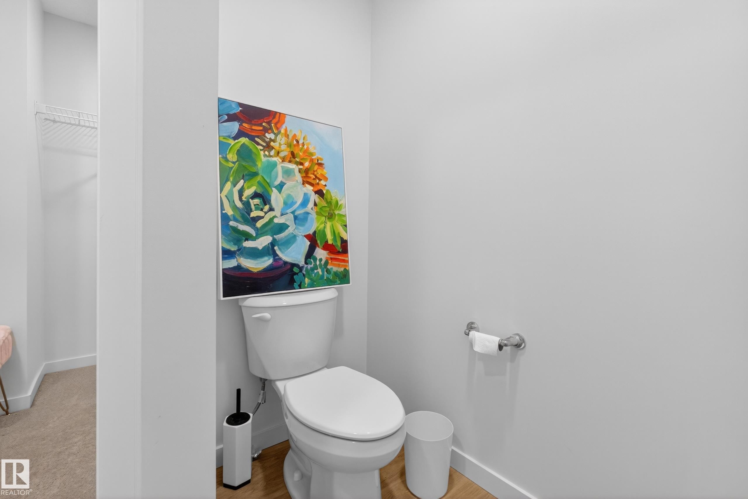 White two-piece toilet with a chrome toilet paper holder - 17023 45 Street, Edmonton, AB