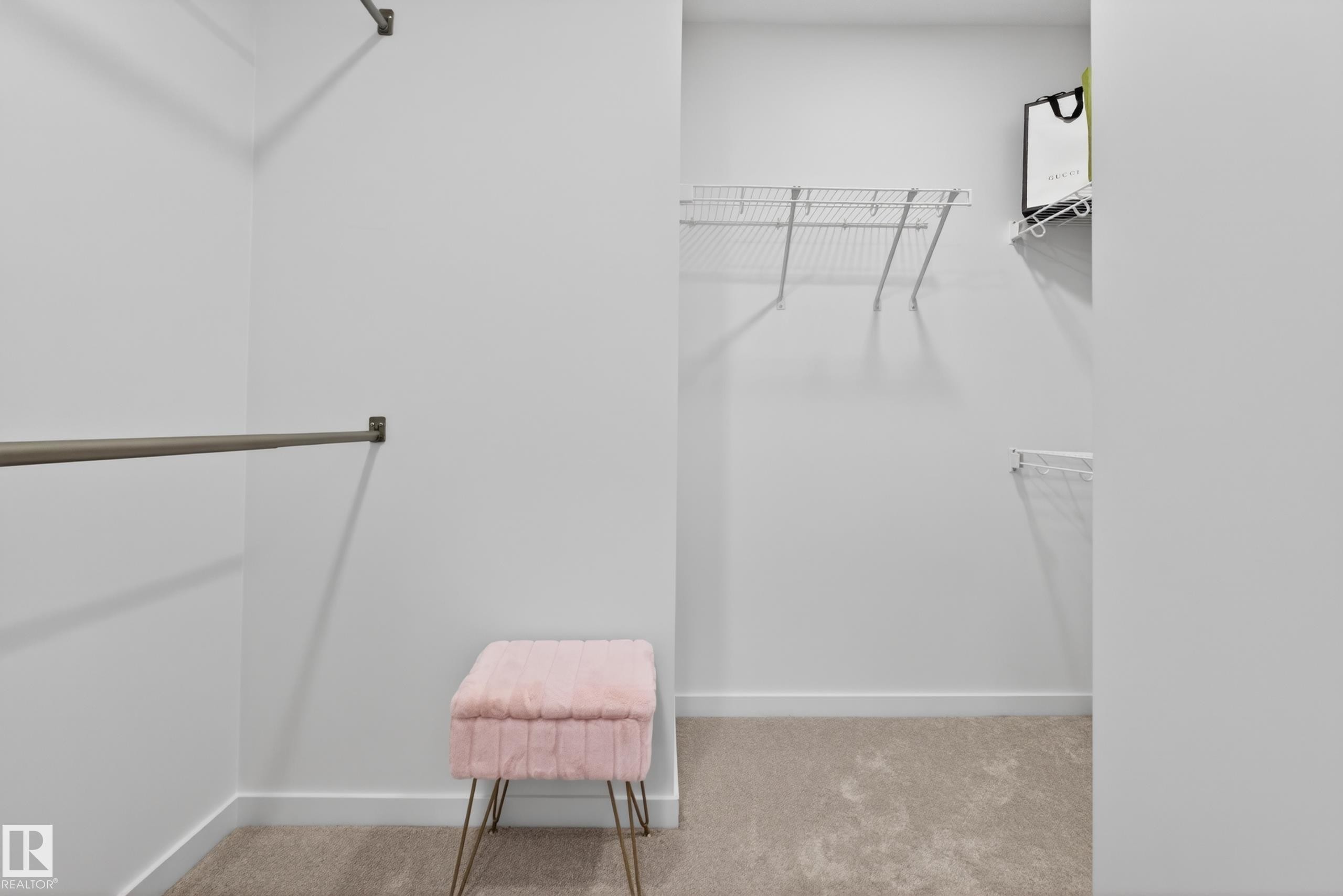 Spacious closet with light neutral wall paint, warm-toned carpeting, built-in wire shelving, and chrome hanging rods - 17023 45 Street, Edmonton, AB