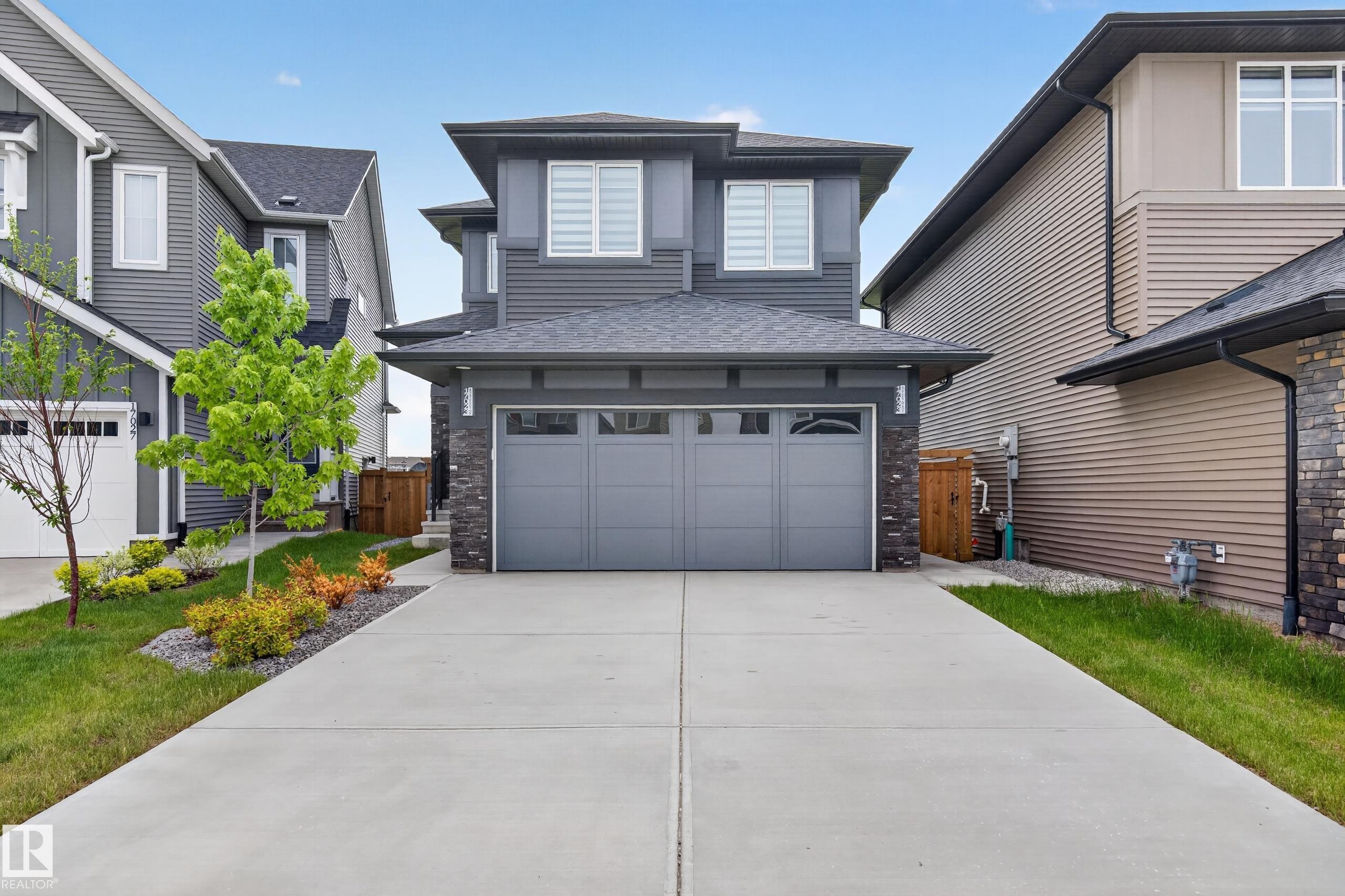 Contemporary two-story exterior featuring dark gray siding and stone accents - 17023 45 Street, Edmonton, AB
