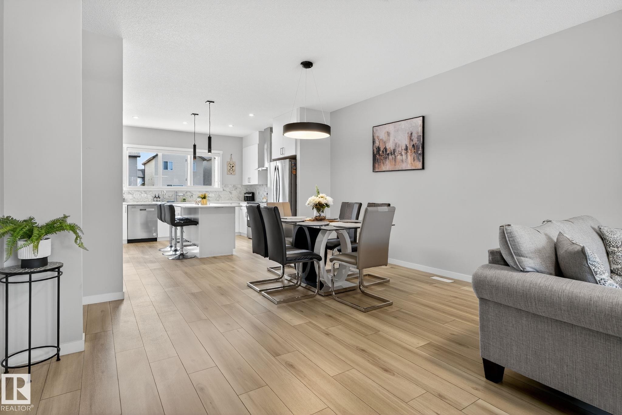 Open-concept living space featuring wood-finish flooring, recessed lighting, and a neutral color palette - 1213 16A Street, Edmonton, AB