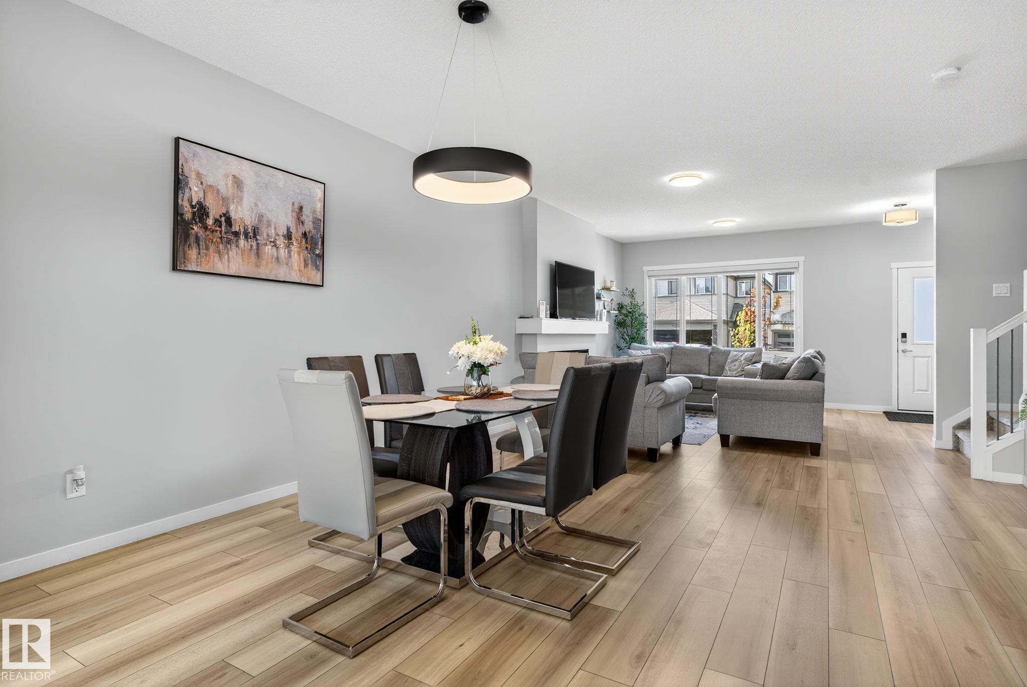 Open-concept living area featuring wood-finish flooring, recessed lighting, and a contemporary pendant light fixture - 1213 16A Street, Edmonton, AB