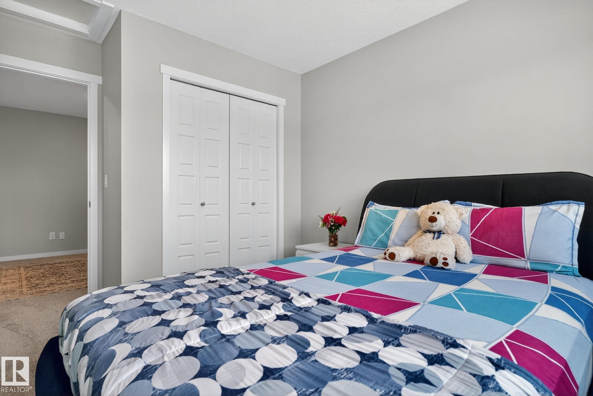 Carpeted room with light gray walls, white trim, and a white bi-fold closet - 1213 16A Street, Edmonton, AB