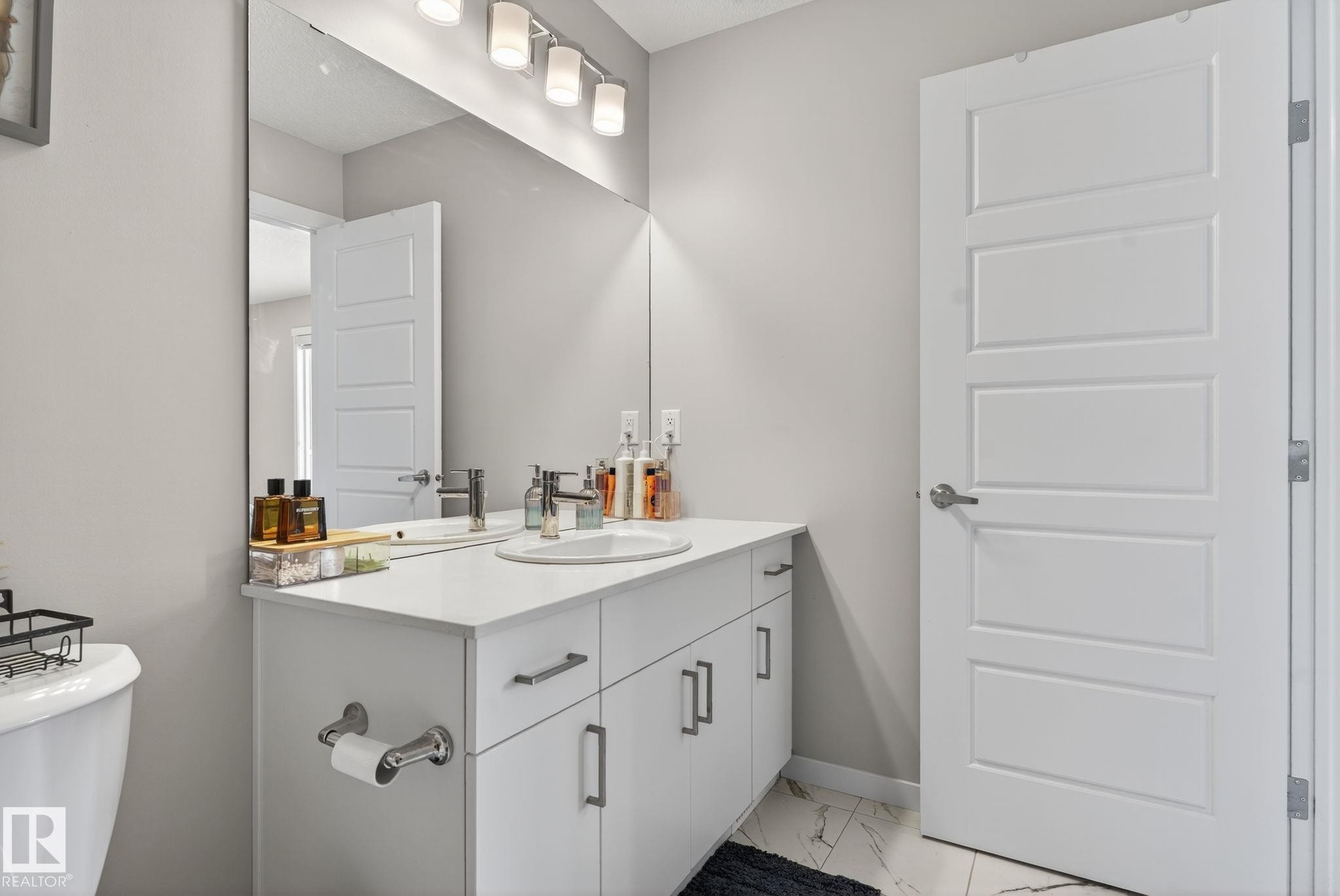 Modern bathroom vanity with a white countertop, undermount sink, and chrome faucet - 1213 16A Street, Edmonton, AB