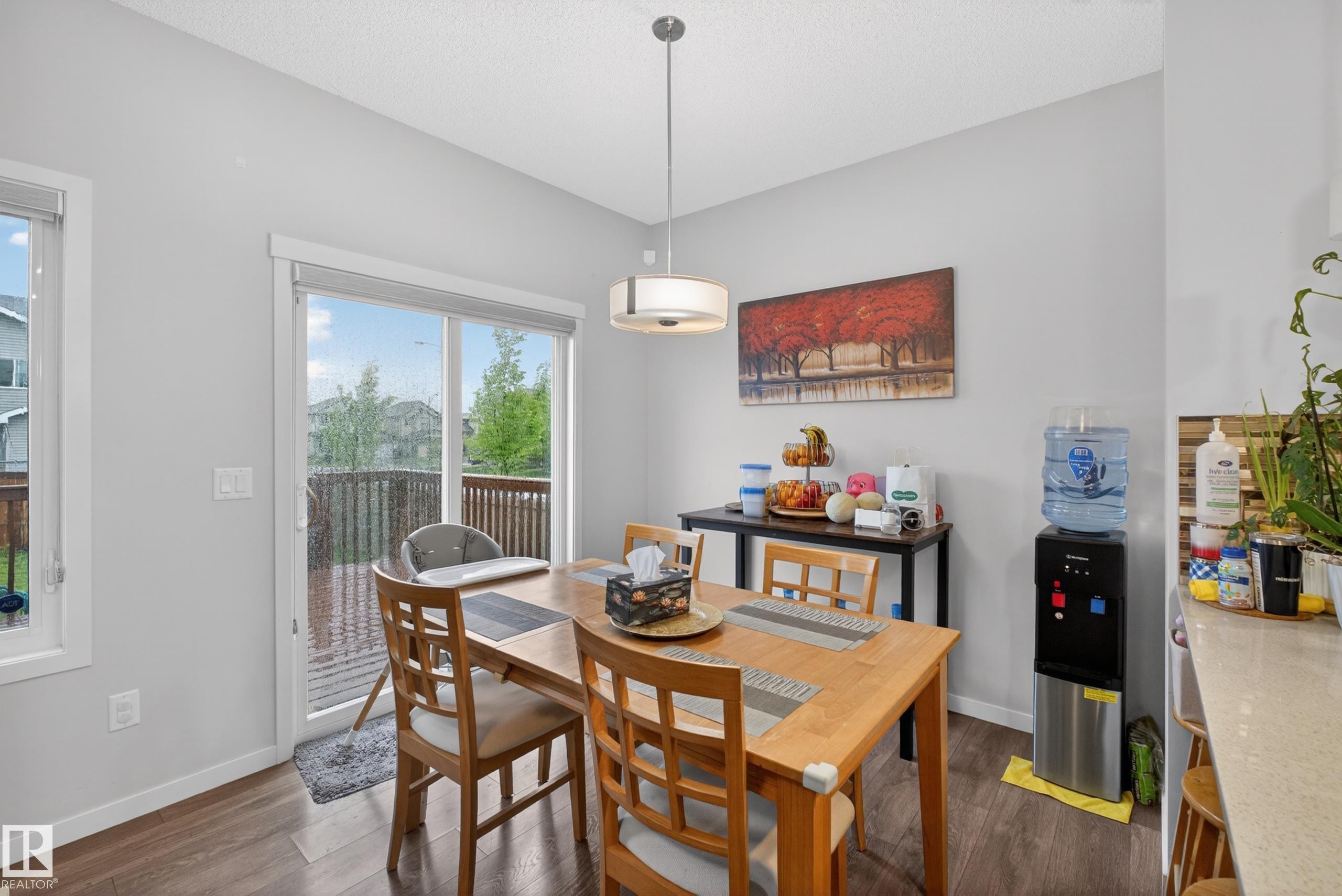 Dining area featuring wood-finish flooring and a contemporary pendant light fixture - 1404 25 Avenue, Edmonton, AB