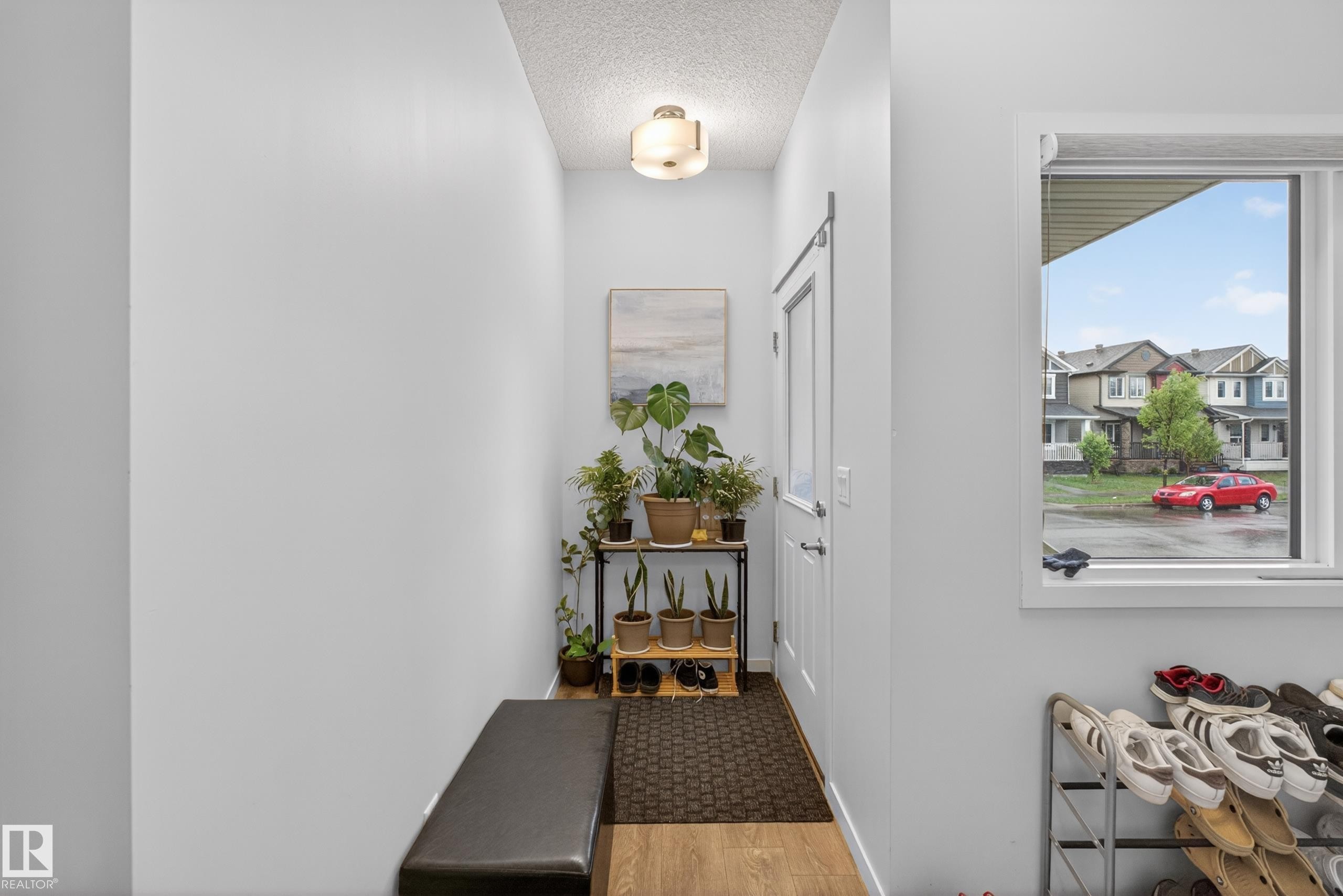 Bright entryway featuring light wood-finish flooring and a white main entry door with chrome hardware - 1404 25 Avenue, Edmonton, AB