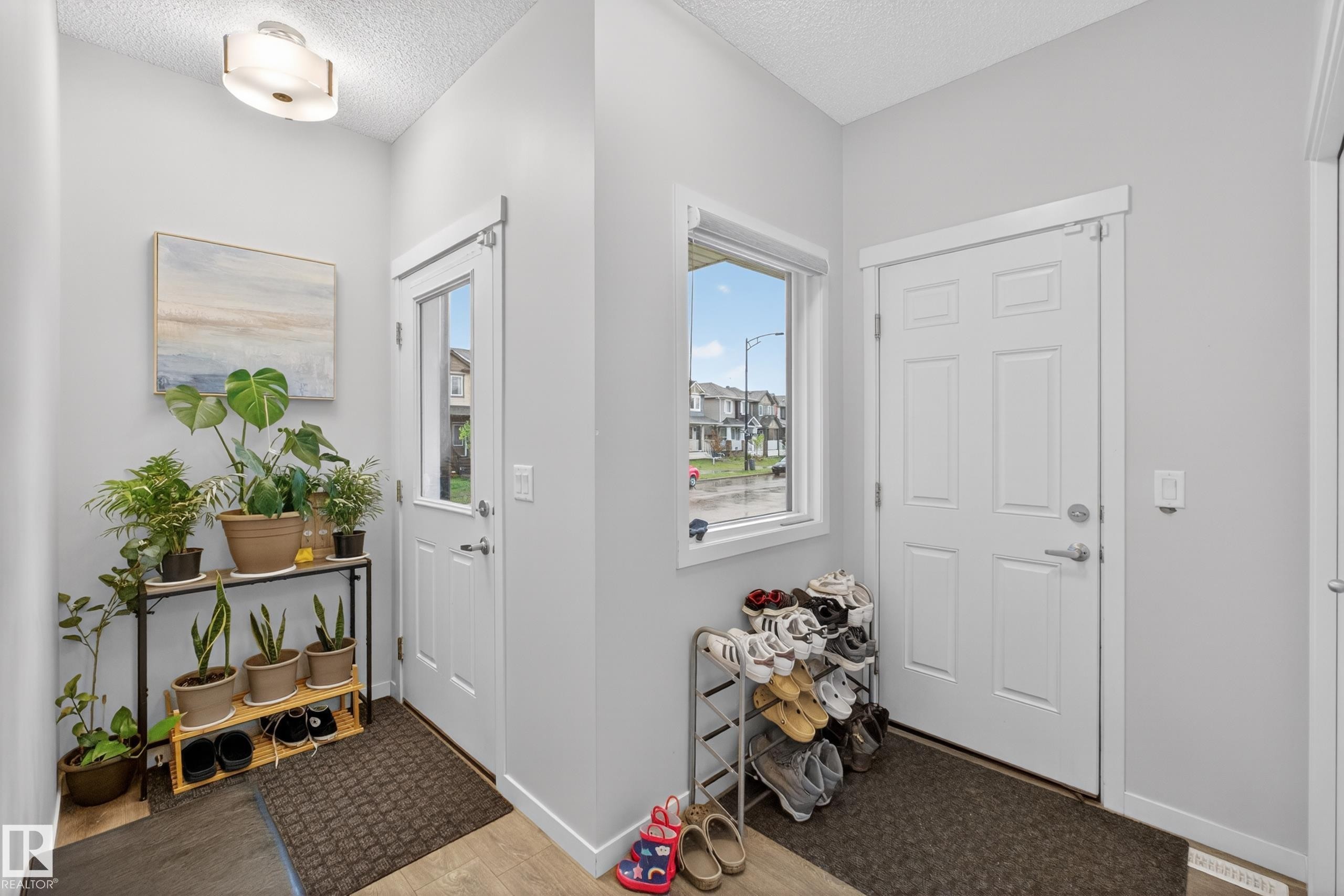 Entryway featuring light gray walls, a flush-mount ceiling light fixture, and wood-finish flooring - 1404 25 Avenue, Edmonton, AB