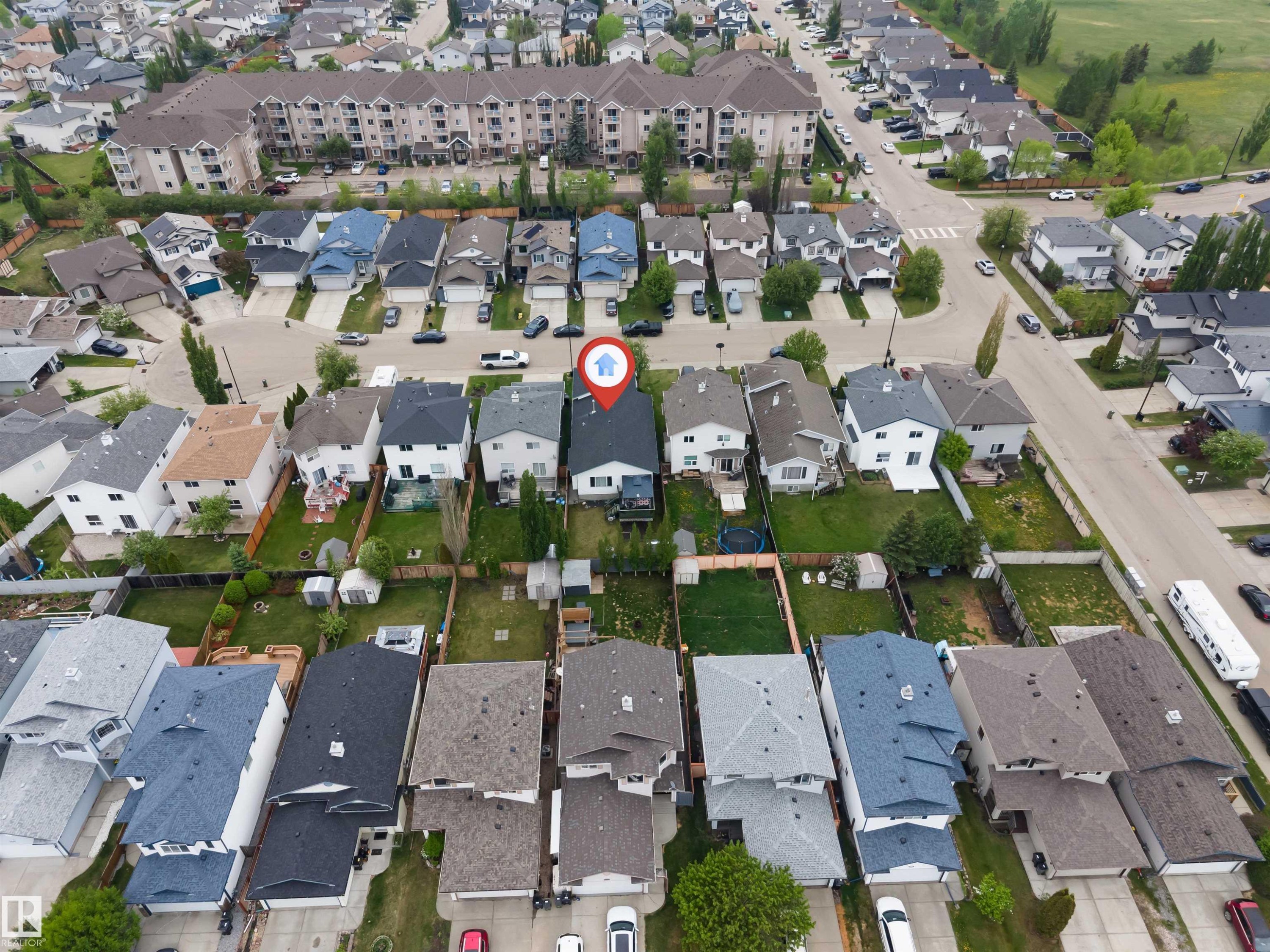 Aerial perspective showcasing a residential neighborhood with detached homes, apartment buildings, and undeveloped green space - 3519 22 Street Nw, Edmonton, AB