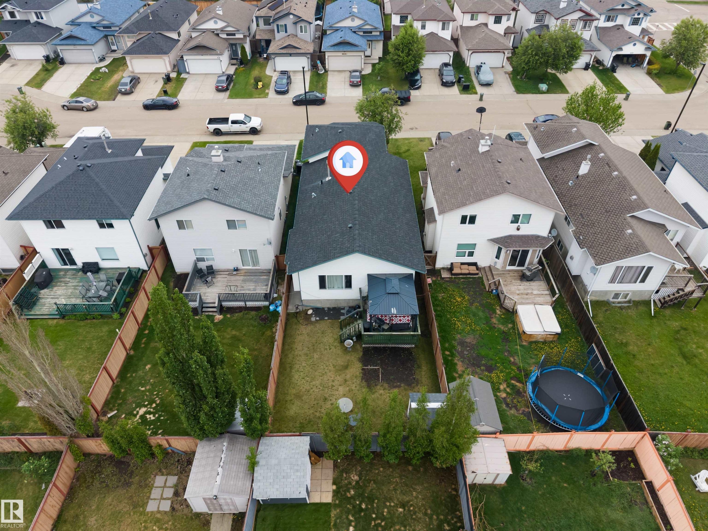 Rear facade featuring a dark shingle roof, white siding, and a wooden deck - 3519 22 Street Nw, Edmonton, AB