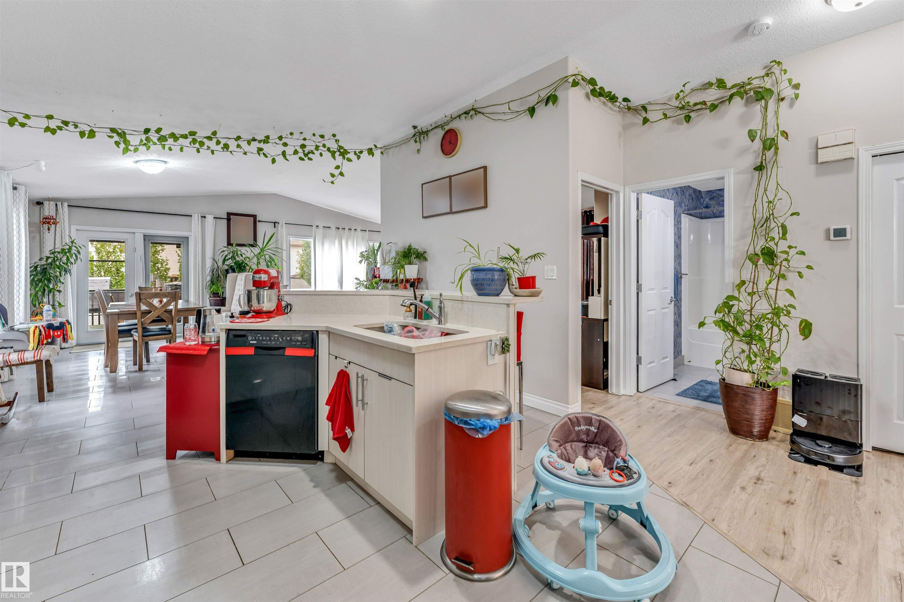 Kitchen featuring light-toned cabinetry, a black dishwasher, and a light-colored countertop - 3519 22 Street Nw, Edmonton, AB
