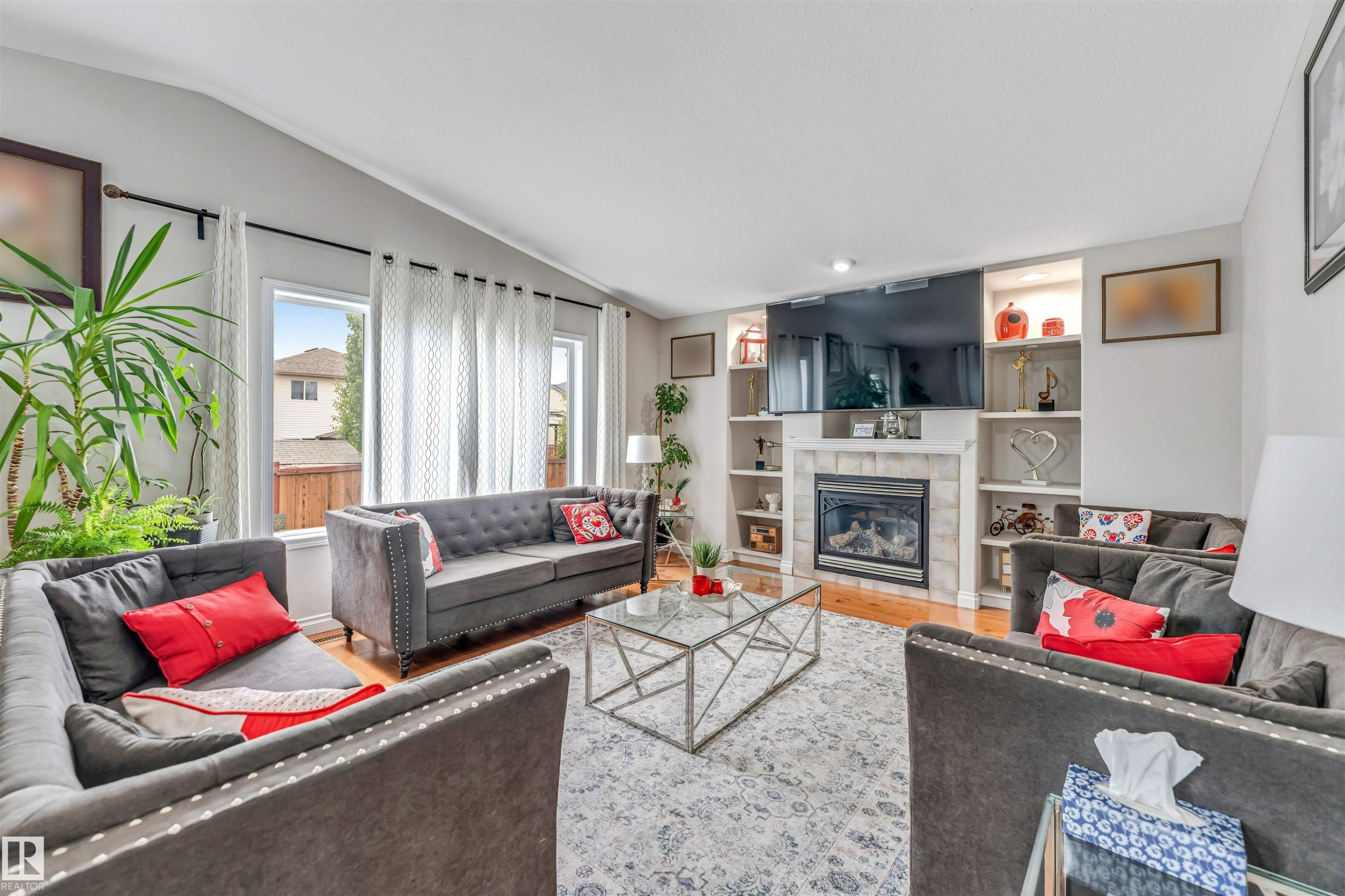 Living area featuring light wood-finish flooring and a stone-surround fireplace - 3519 22 Street Nw, Edmonton, AB