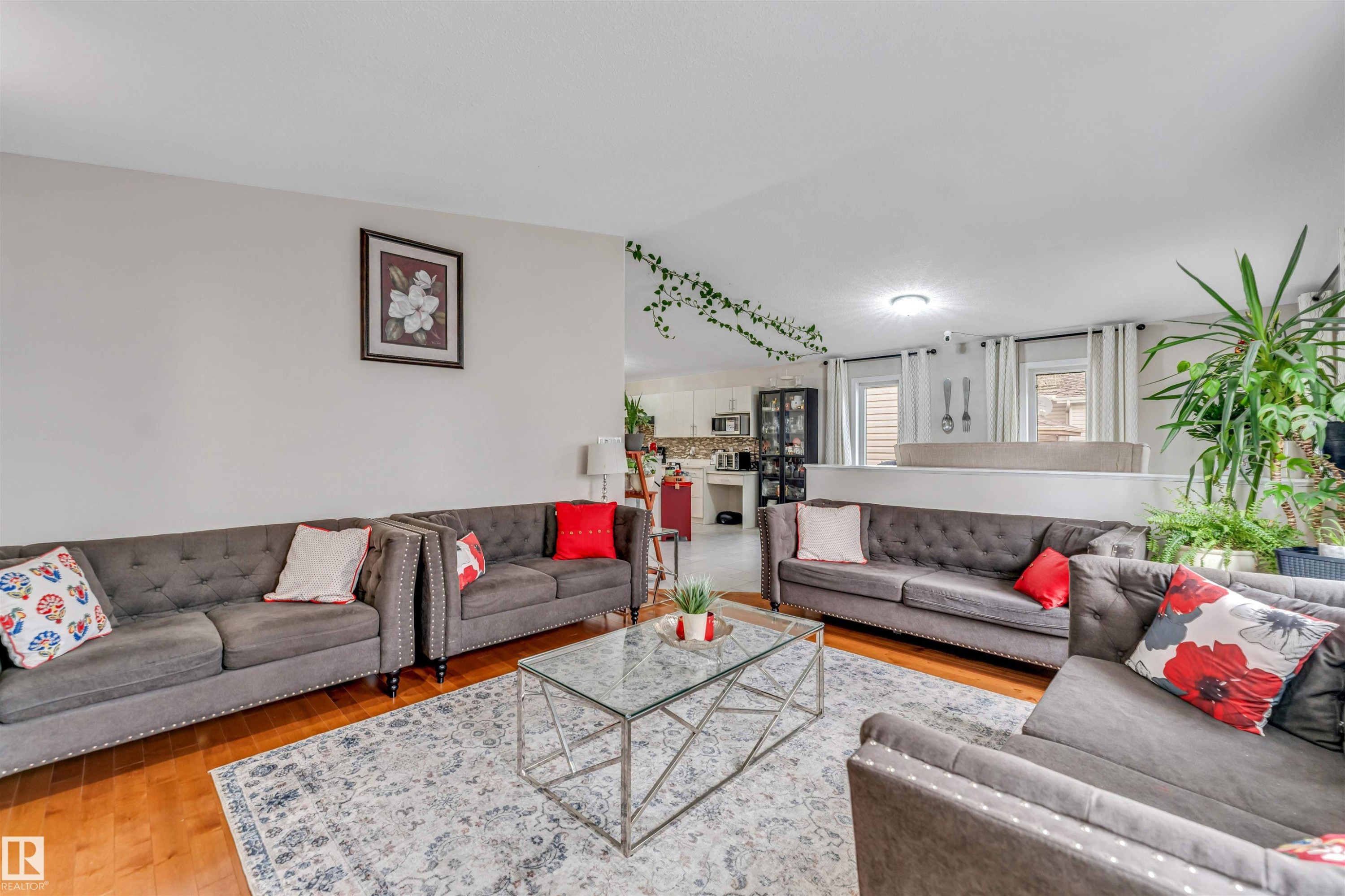 Open-concept living area featuring hardwood flooring, a decorative area rug, and recessed lighting - 3519 22 Street Nw, Edmonton, AB