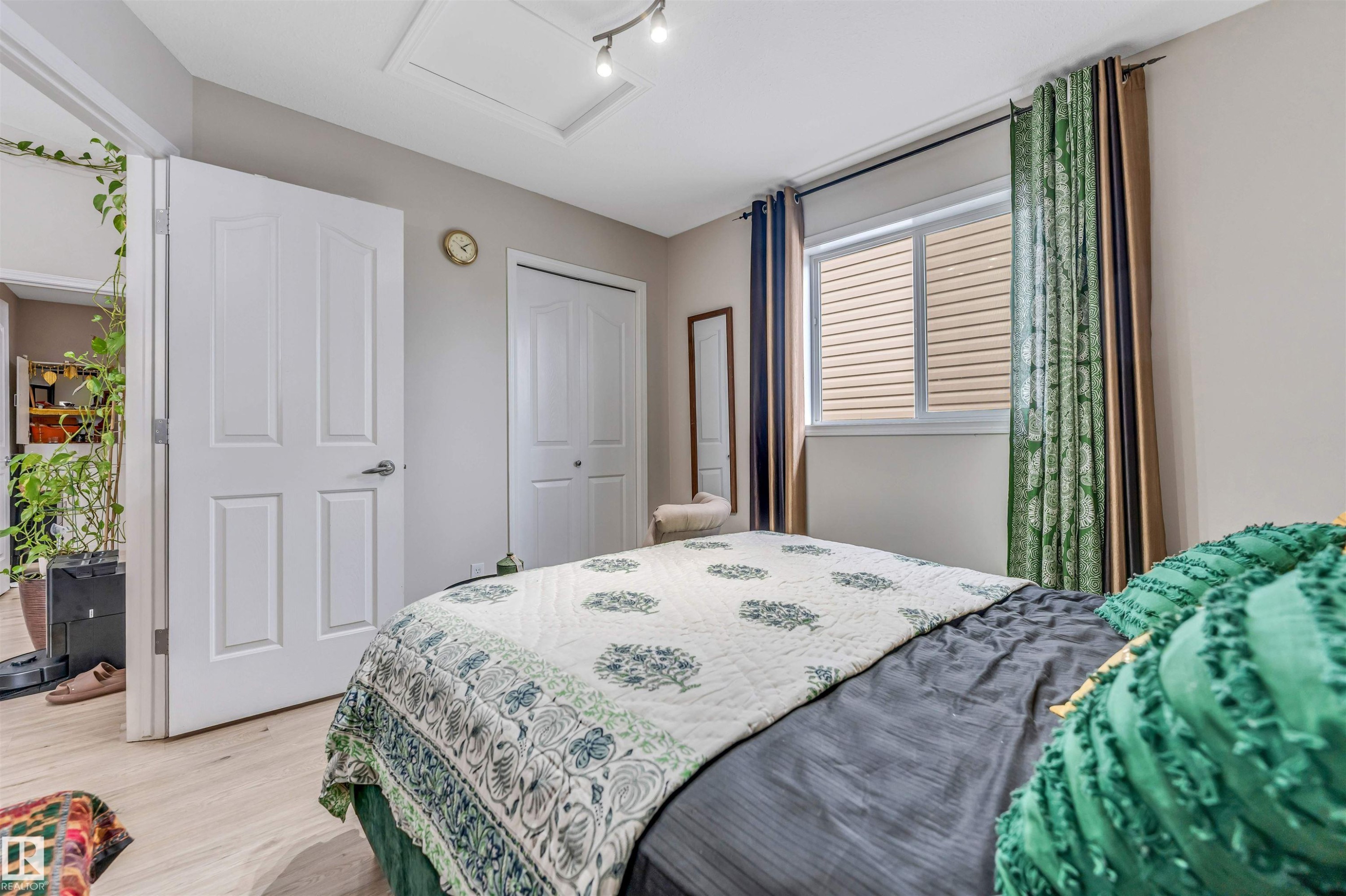 Interior room featuring light wood-finish flooring, a white paneled door, and a horizontal window with blinds - 3519 22 Street Nw, Edmonton, AB