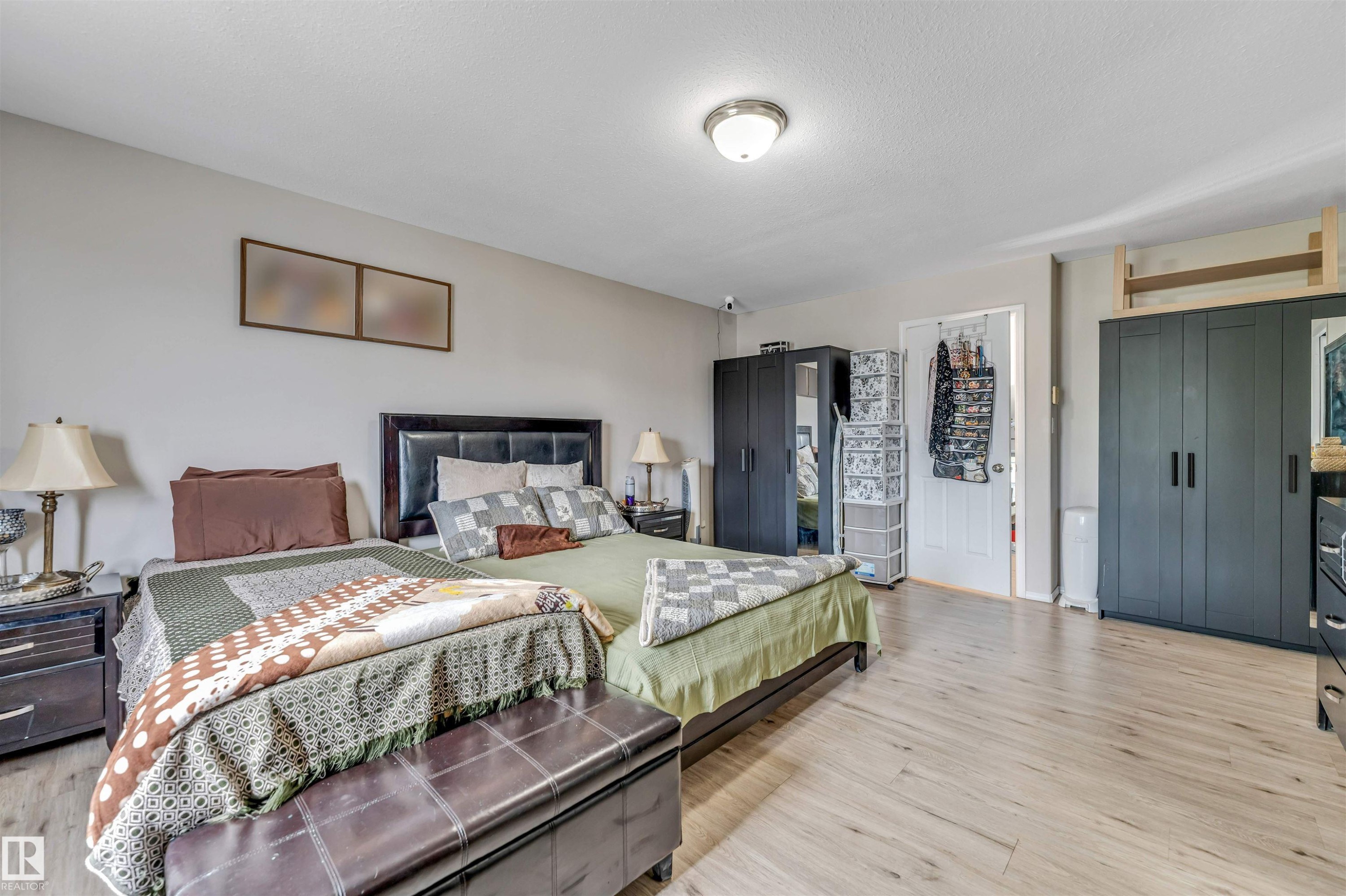Spacious interior featuring wood-finish flooring, neutral wall tones, and a ceiling-mounted light fixture - 3519 22 Street Nw, Edmonton, AB