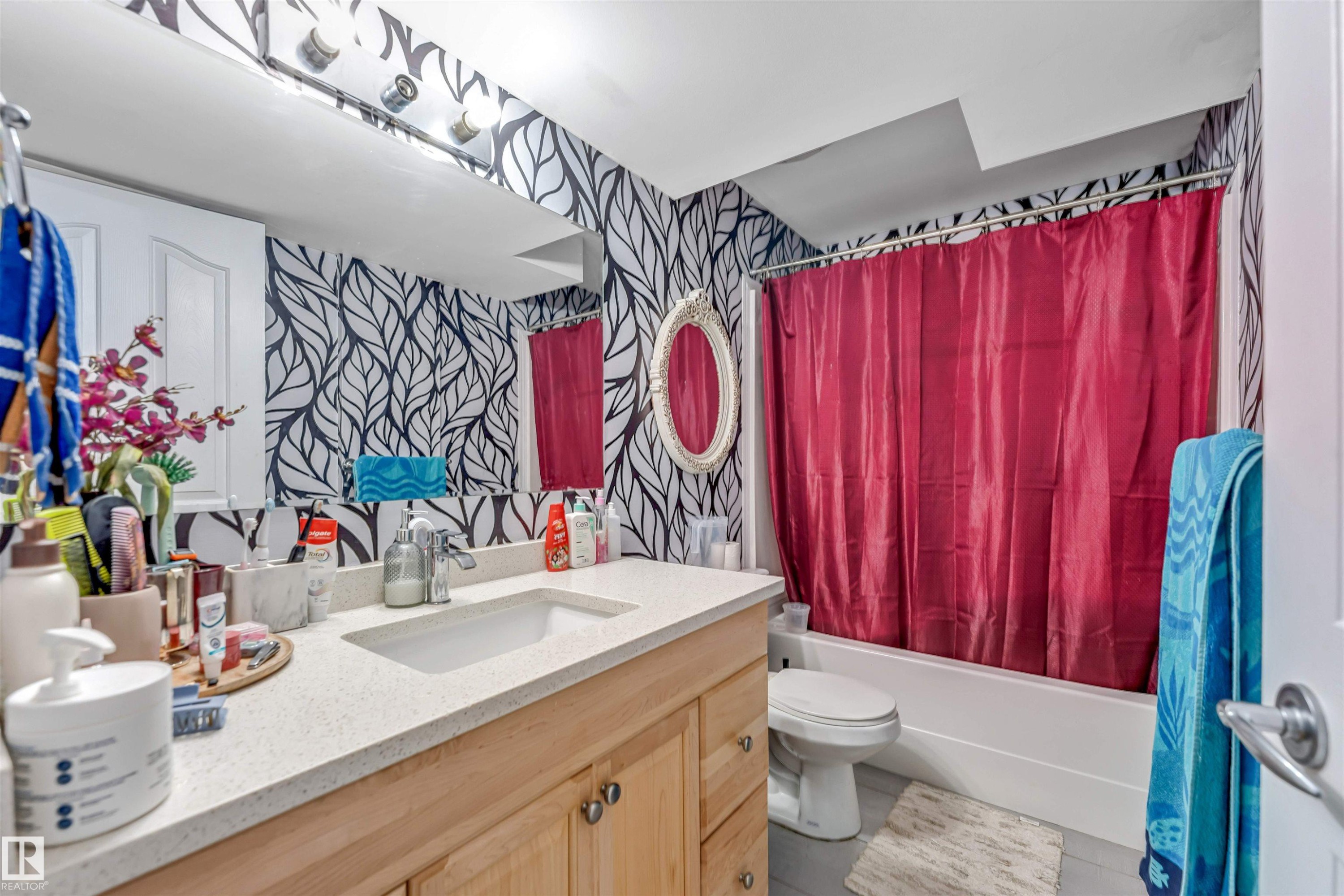 Bathroom featuring a vanity with wood-finish cabinetry, a light-toned countertop, and an undermount sink - 3519 22 Street Nw, Edmonton, AB