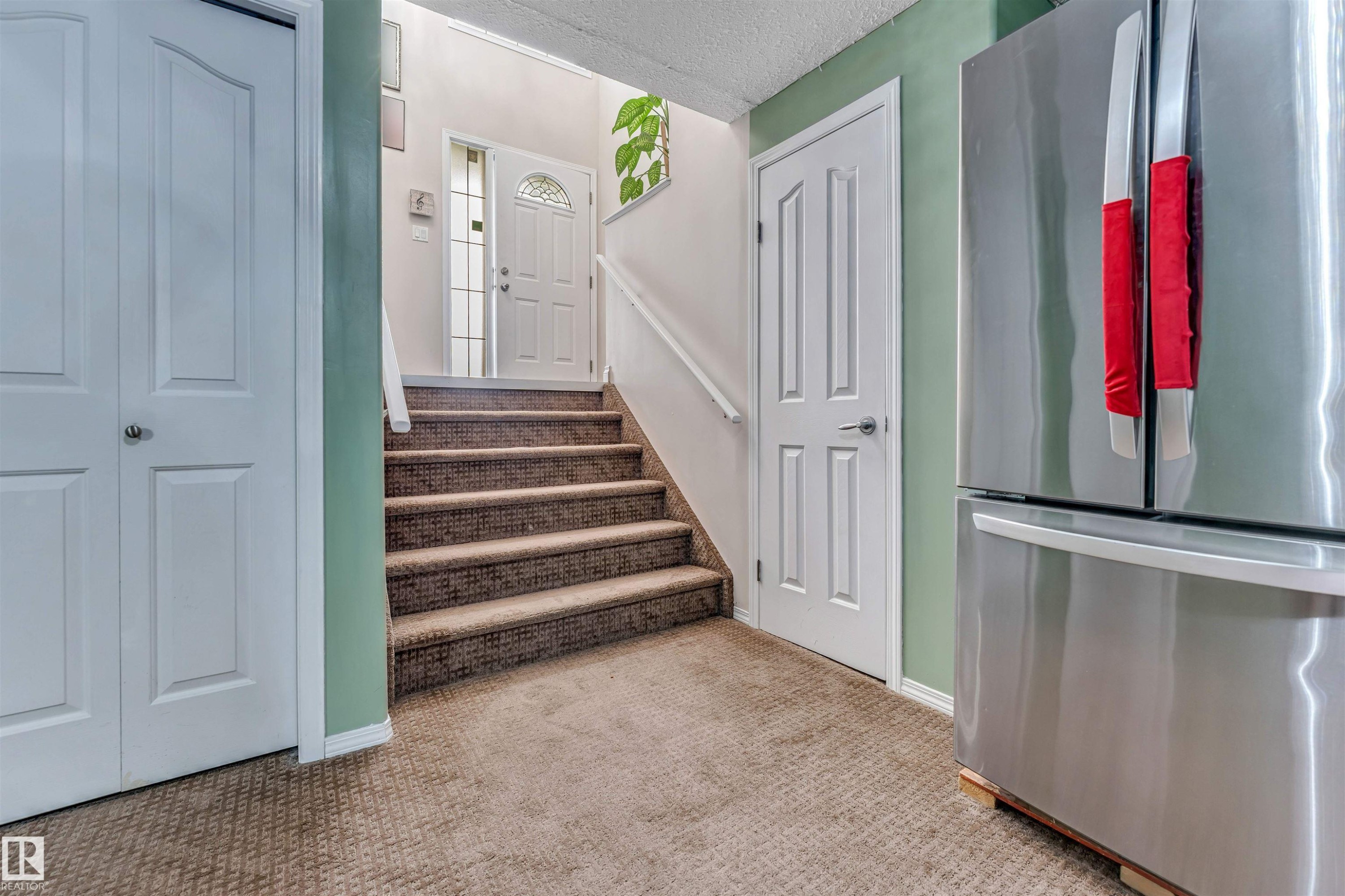 Carpeted stairway with white railing and contrasting light green wall - 3519 22 Street Nw, Edmonton, AB