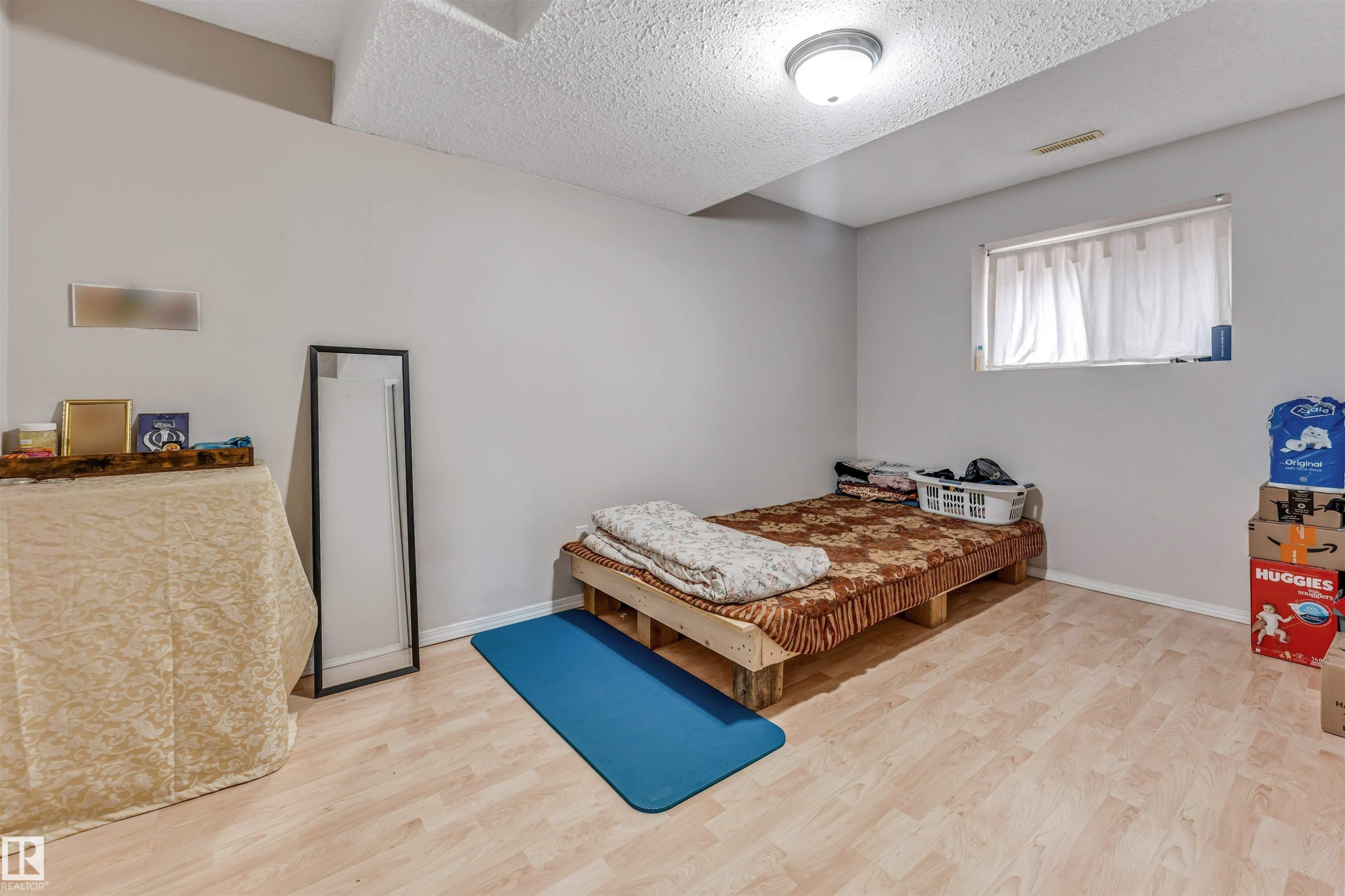 Bright room featuring light wood-finish flooring, a white textured ceiling, and neutral-toned walls - 3519 22 Street Nw, Edmonton, AB