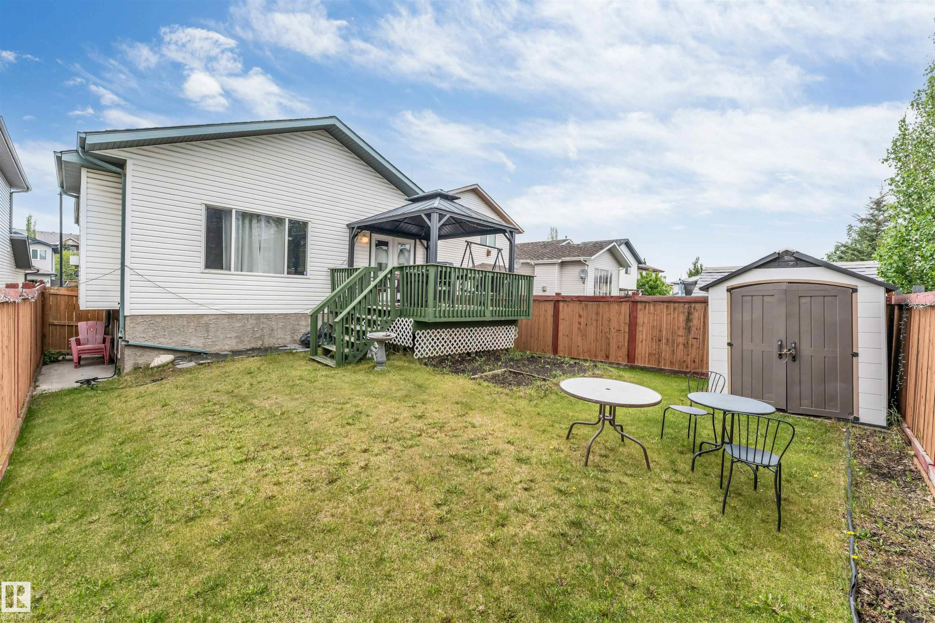 Spacious backyard featuring a sloped lawn and a fenced perimeter - 3519 22 Street Nw, Edmonton, AB