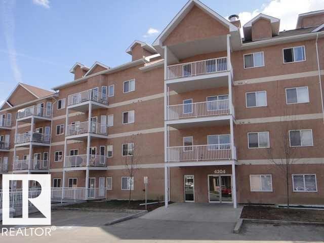 Multi-story residential building featuring a brick exterior and multiple private balconies with white railings - 425 4304 139 Avenue, Edmonton, AB