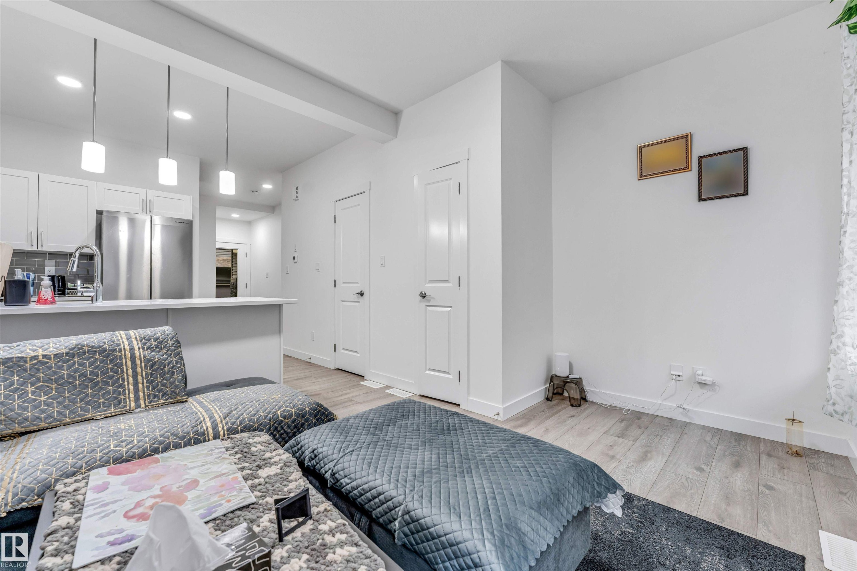 Open-concept living area featuring light wood-finish flooring and bright white walls - 45 2710 66 Street, Edmonton, AB