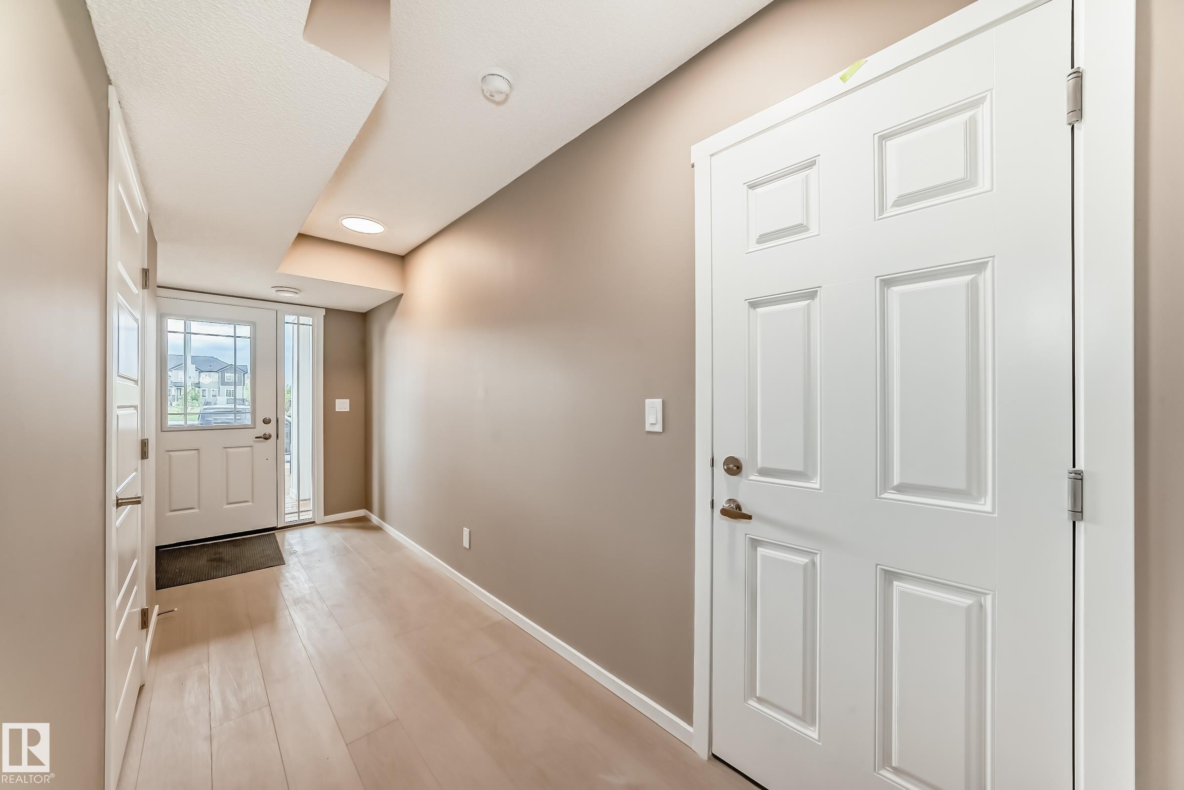 Foyer featuring light wood-finish flooring, recessed lighting, and a white paneled entry door with sidelights - 1210 Stoneside Road, Sherwood Park, AB - Indoor Photo Showing Other Room