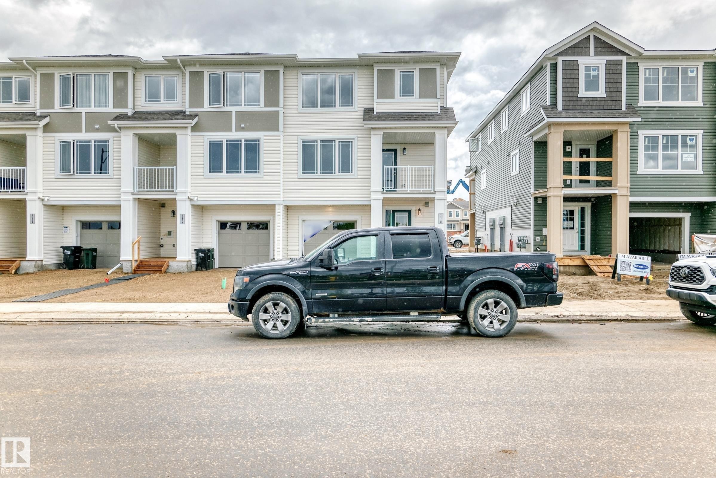 New construction townhome featuring a two-tone facade, attached garage, and a balcony with white railings - 1210 Stoneside Road, Sherwood Park, AB - Outdoor With Balcony With Facade