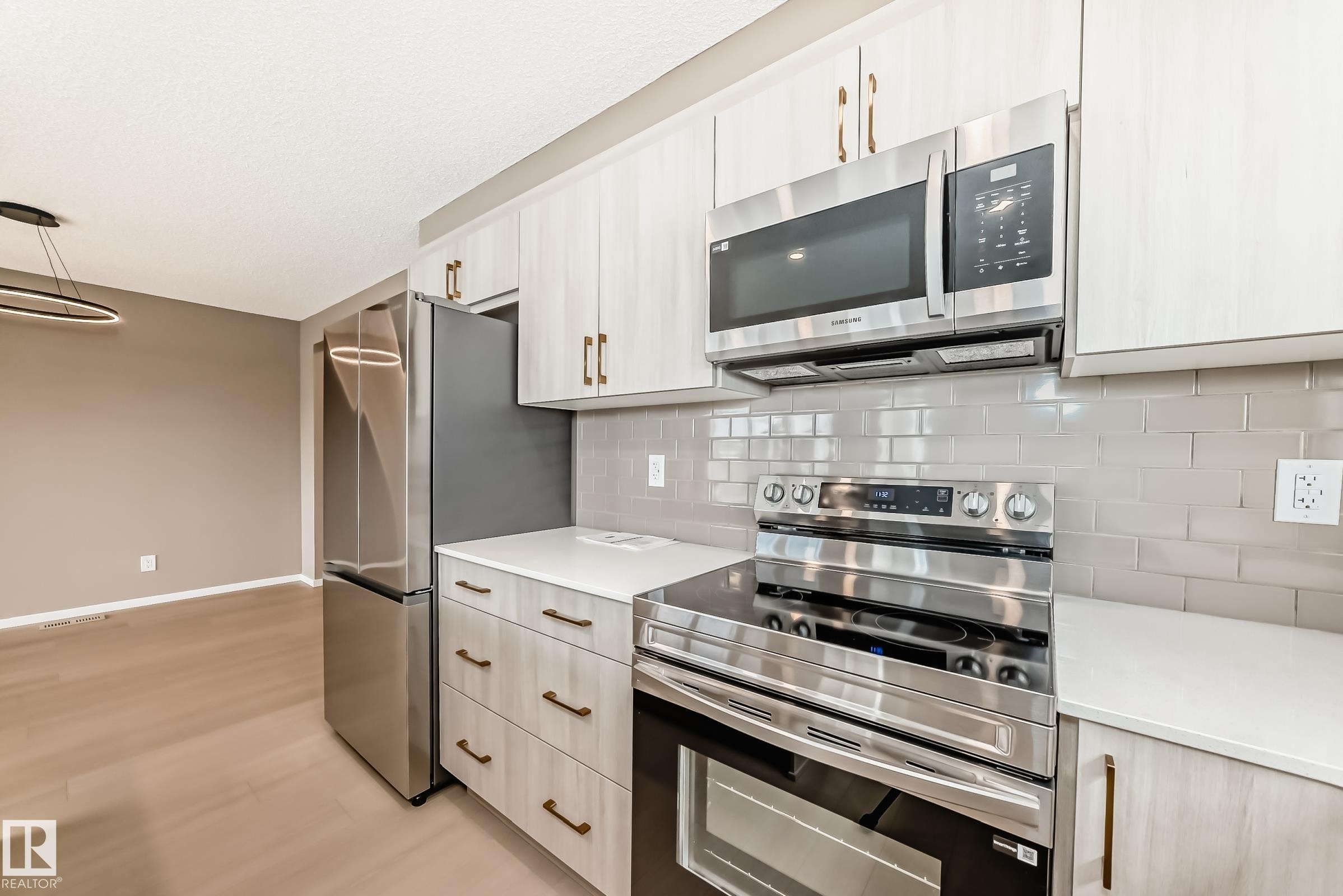 Kitchen featuring stainless steel appliances, light wood-finish cabinetry with gold-tone hardware, white countertops, and a gray subway tile backsplash - 1210 Stoneside Road, Sherwood Park, AB - Indoor Photo Showing Kitchen With Upgraded Kitchen