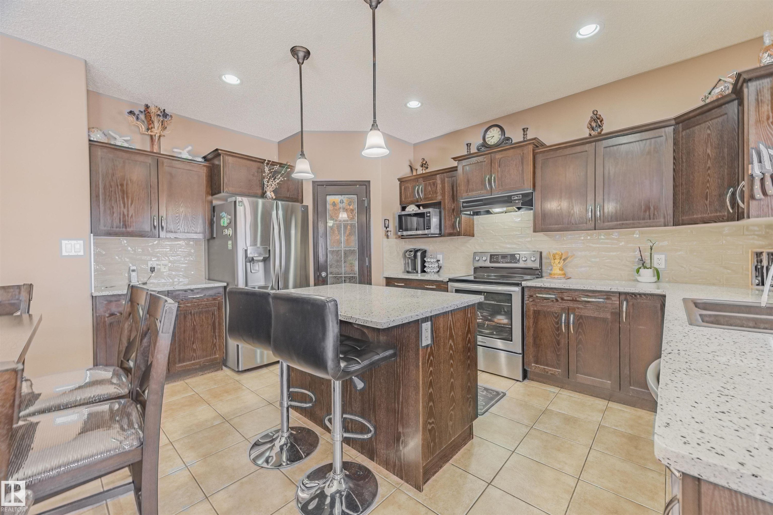 Fridge changed in 2024. Dishwasher and Stove purchased in 2015. Quartz countertops & kitchen backsplash done in 2022. - 57 Homestead Crescent Nw, Edmonton, AB - Indoor Photo Showing Kitchen With Double Sink With Upgraded Kitchen