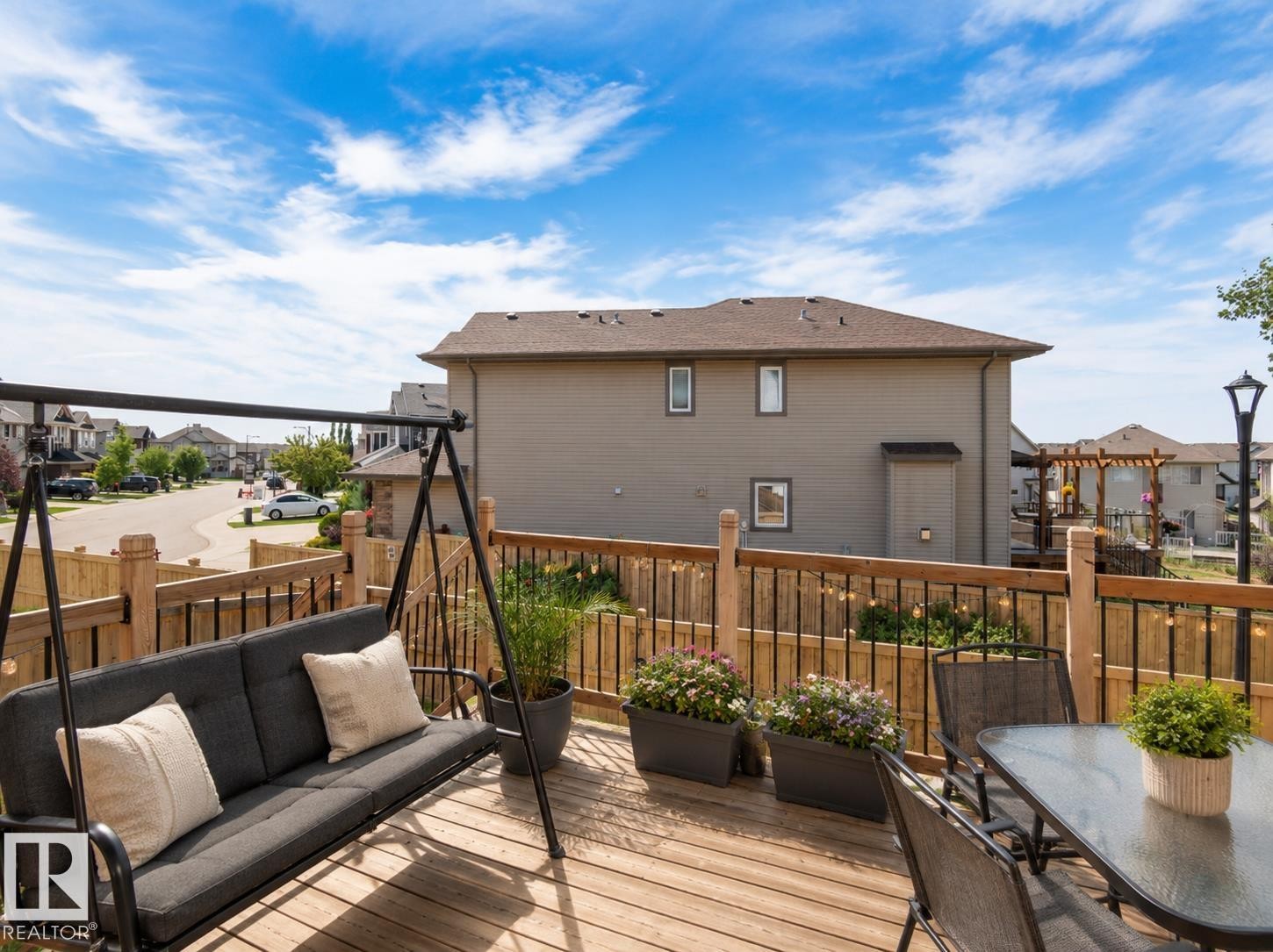 Expansive wood-finish deck with a wood railing and black balusters - 1840 56 Street, Edmonton, AB