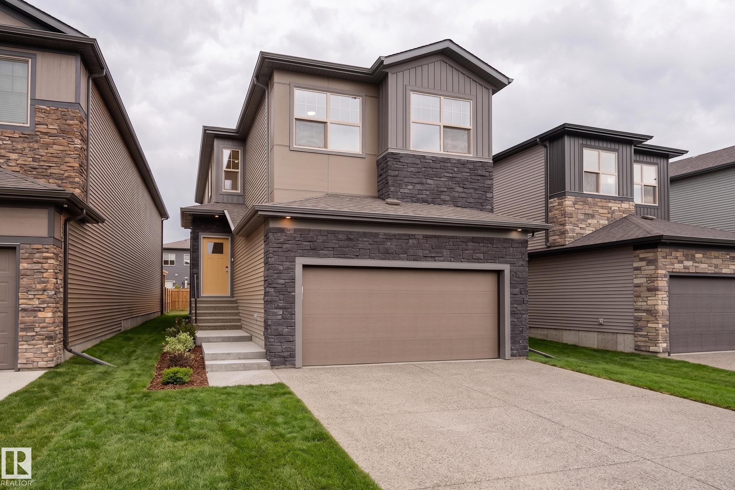 Modern two-story residence featuring a combination of siding and stone veneer exterior - 115 Garneau Gate, Spruce Grove, AB