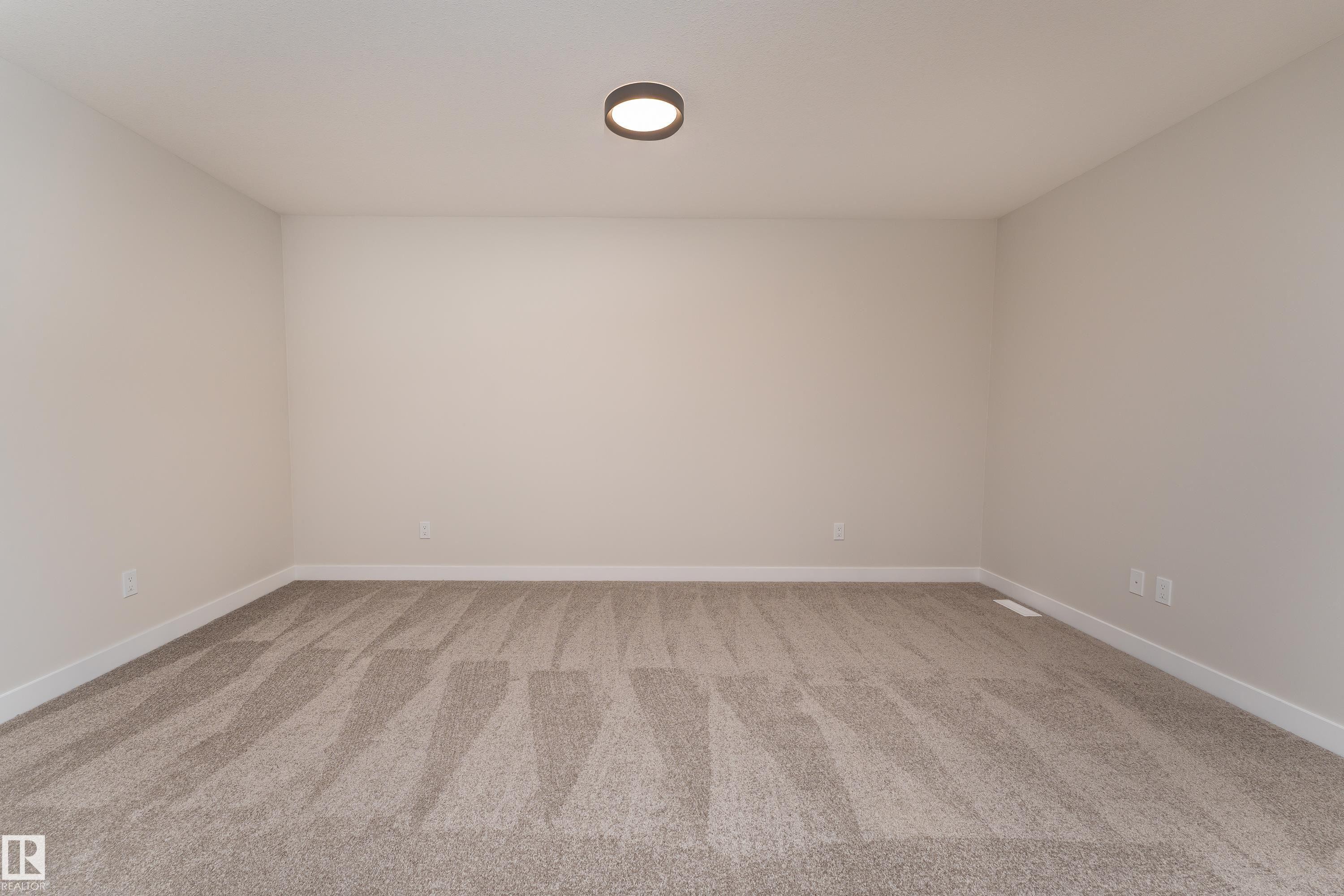Expansive room with neutral carpeting and light-toned walls - 115 Garneau Gate, Spruce Grove, AB