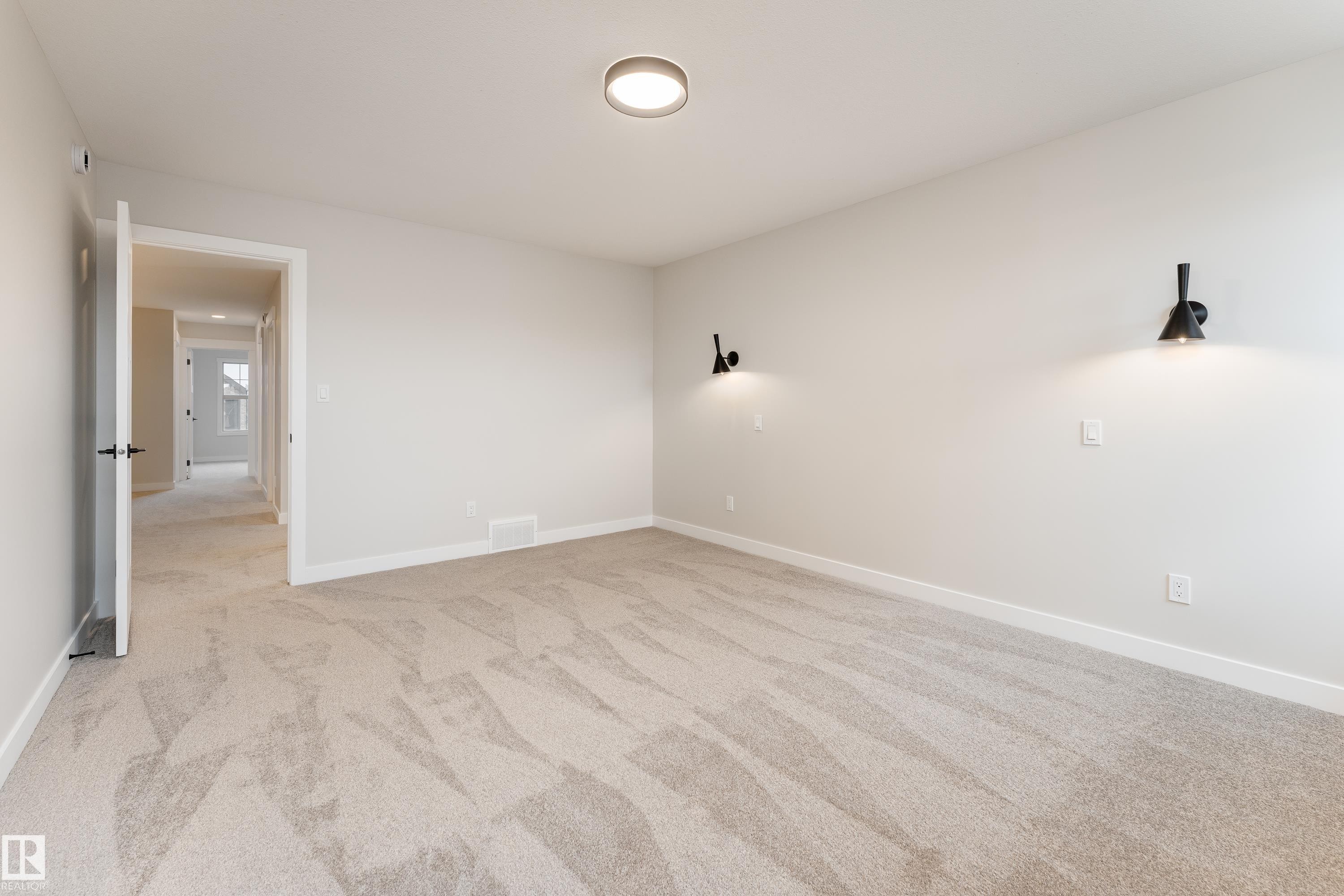 Spacious room featuring neutral carpeting, light-toned walls, and white trim - 115 Garneau Gate, Spruce Grove, AB