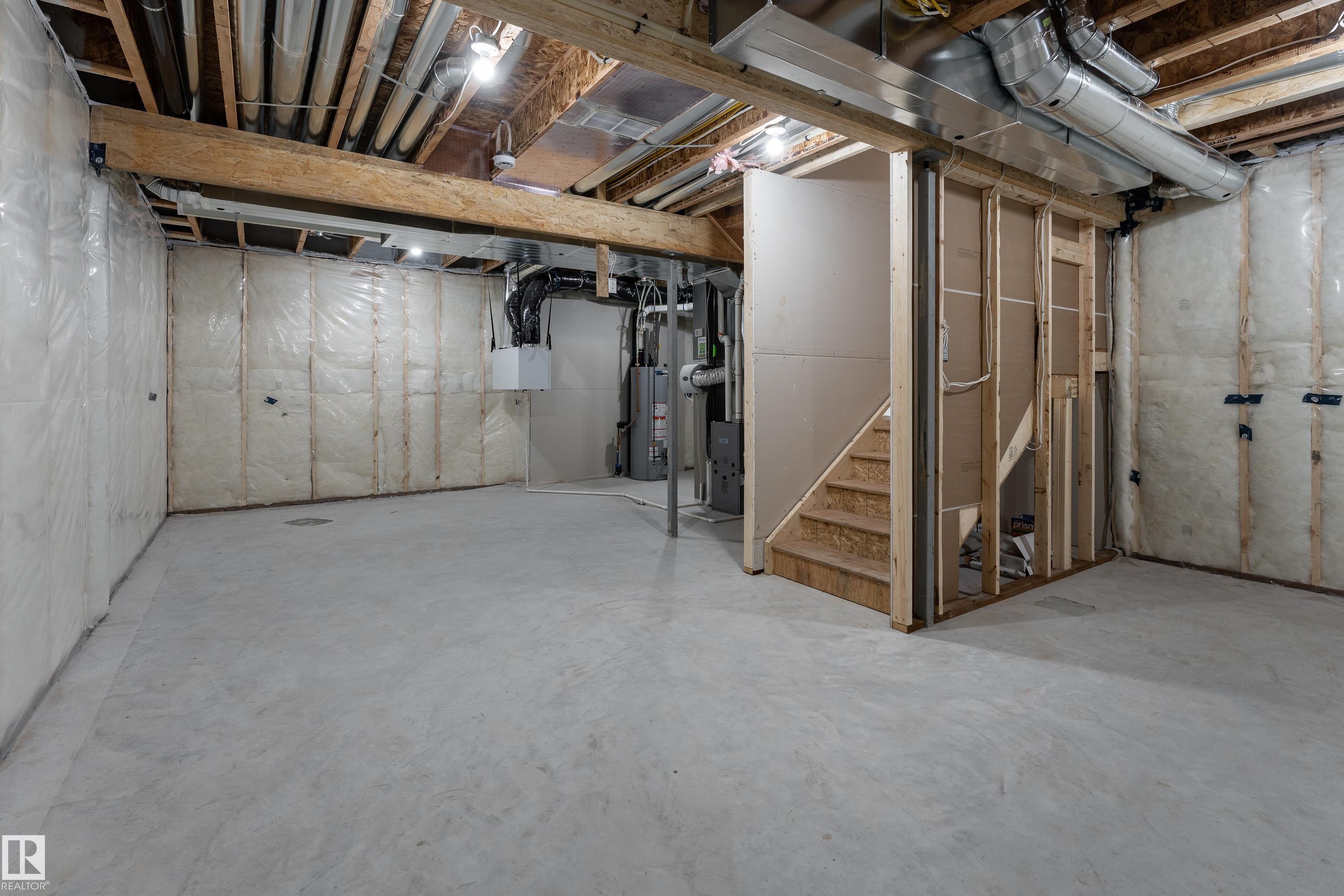 Unfinished basement with concrete flooring, exposed wood beams, and insulated walls - 115 Garneau Gate, Spruce Grove, AB