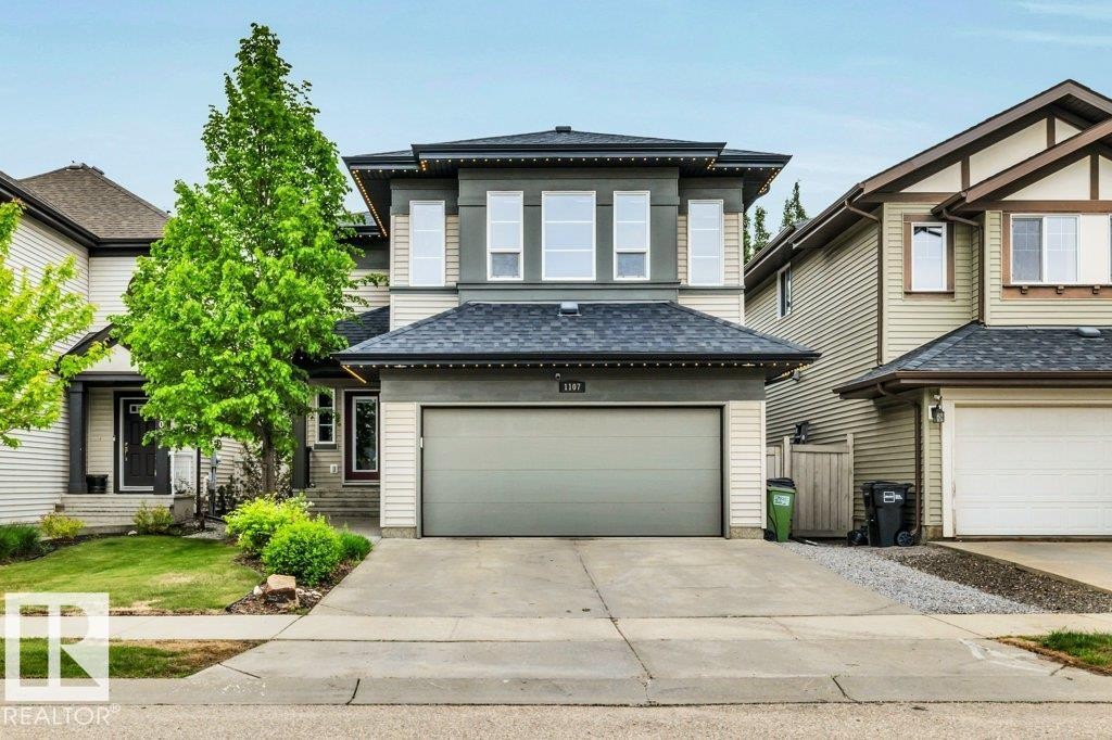 Contemporary two-story residence featuring a two-car garage, partial stone facade, and a covered porch entry - 1107 Chahley Crest, Edmonton, AB