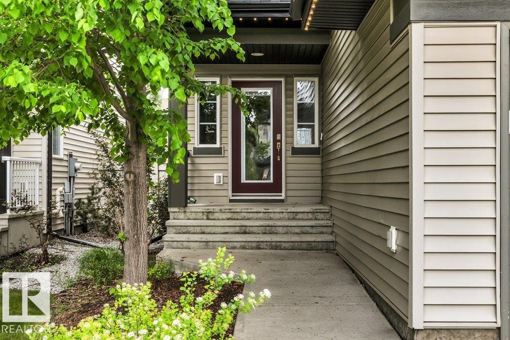 Entryway featuring a dark wood-finish door with glass panels, flanked by two side windows - 1107 Chahley Crest, Edmonton, AB