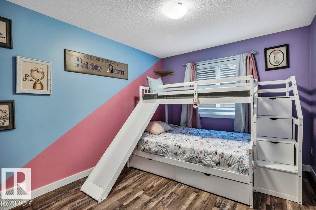 White bunk bed system featuring an integrated slide and staircase with storage drawers - 1107 Chahley Crest, Edmonton, AB