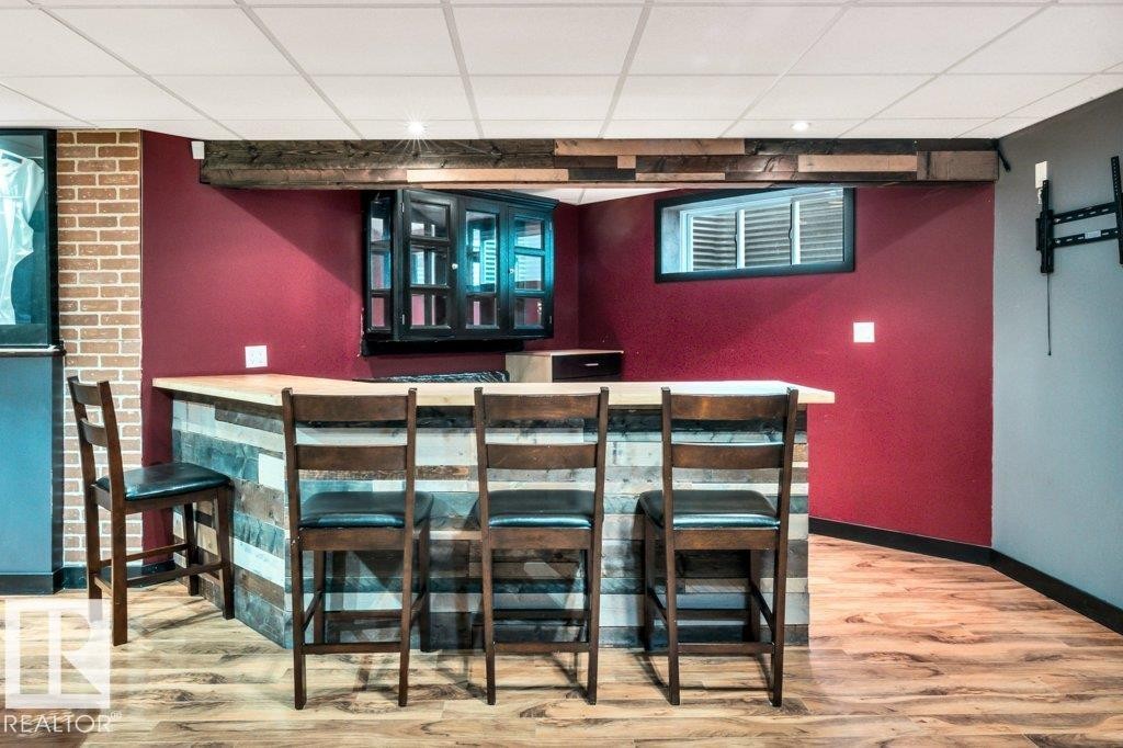 Custom bar area featuring a wood-finish countertop, paneled front, and built-in cabinetry - 1107 Chahley Crest, Edmonton, AB