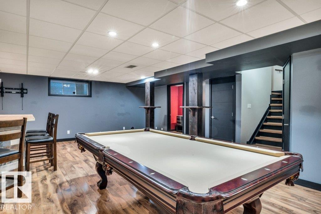 Finished basement space featuring wood-finish flooring, recessed lighting, and a drop ceiling - 1107 Chahley Crest, Edmonton, AB