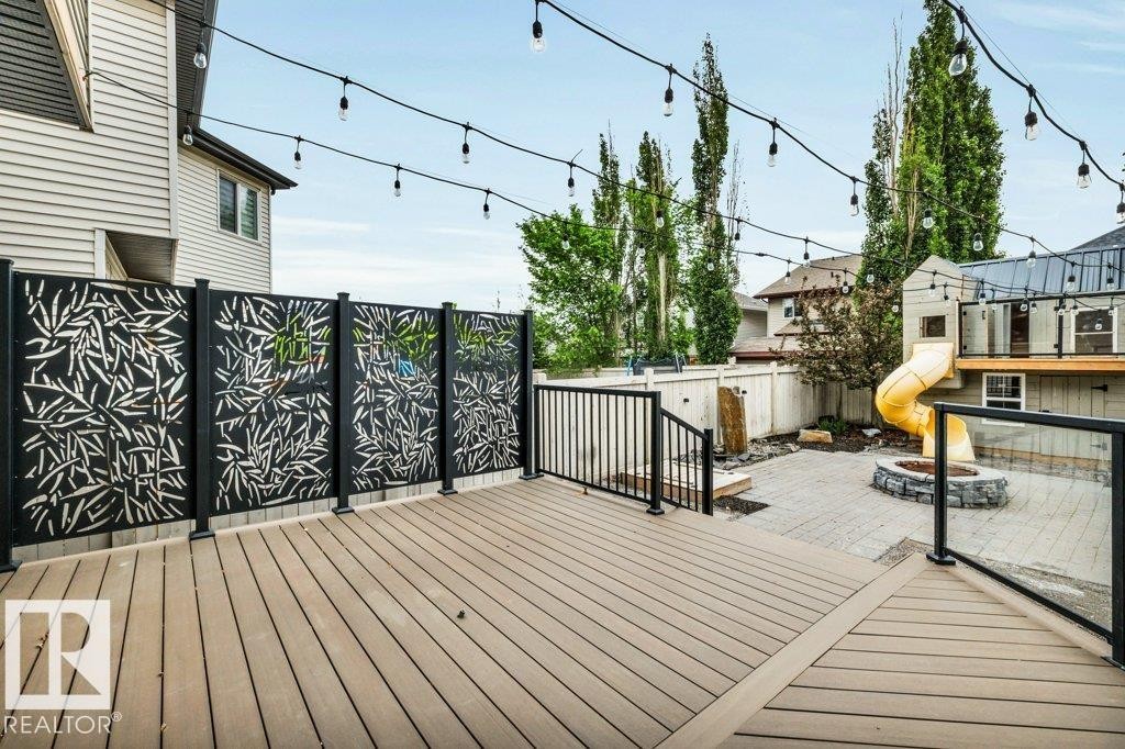 Expansive exterior deck featuring durable composite decking, decorative privacy screening, and black metal railings - 1107 Chahley Crest, Edmonton, AB