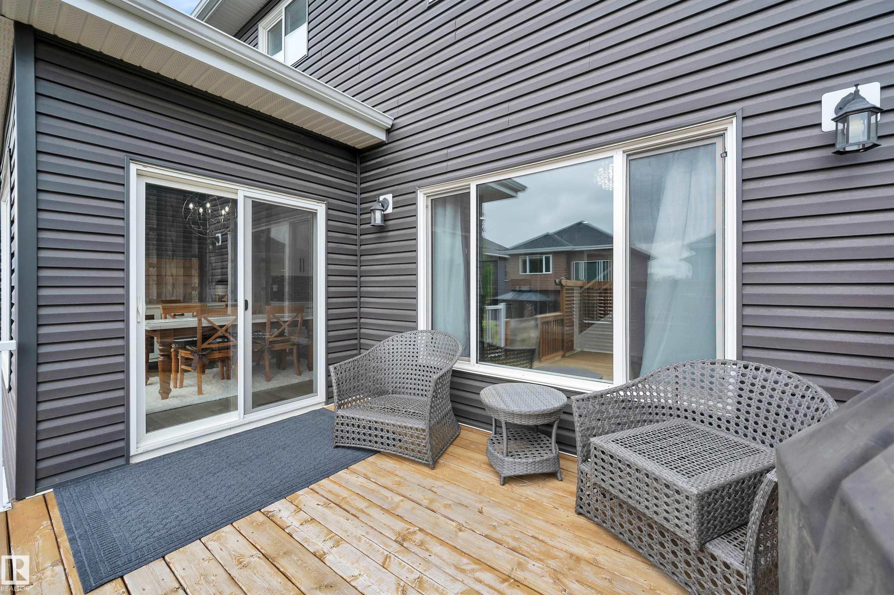Expansive wood-finish deck featuring dark gray siding and white trim - 3898 Robins Crescent Nw, Edmonton, AB - Outdoor With Deck Patio Veranda With Exterior