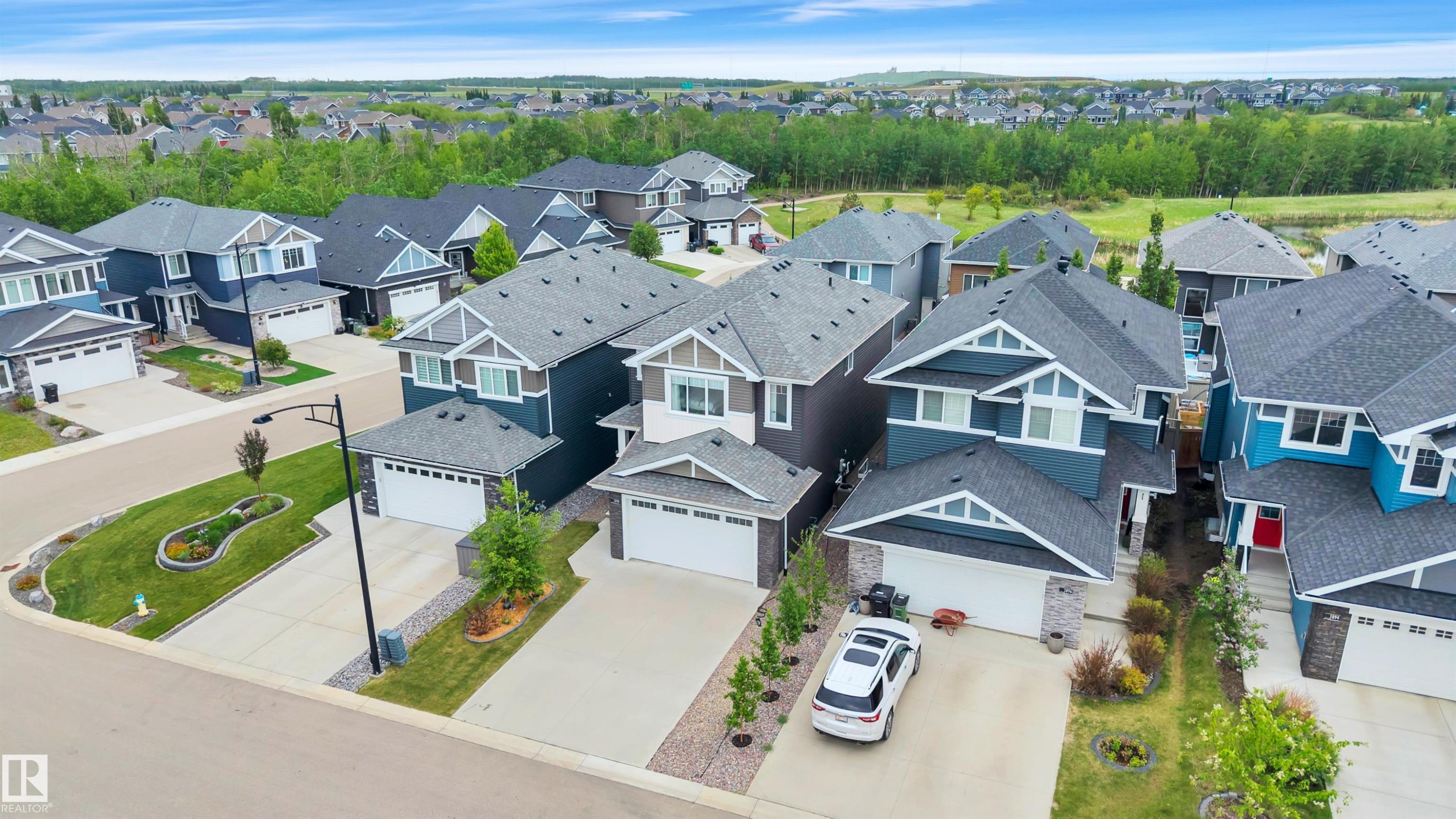 Modern residential neighborhood featuring diverse exterior architectural styles, attached garages, and concrete driveways - 3898 Robins Crescent Nw, Edmonton, AB - Outdoor With Facade With View