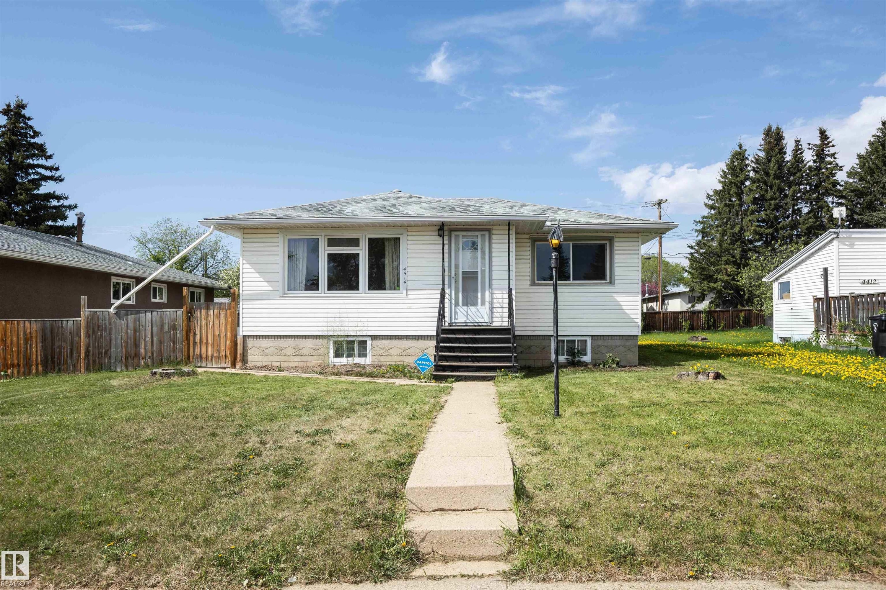 White siding residence with a grey shingled roof and a concrete front walkway - 4414 54 Avenue, Barrhead, AB - Outdoor
