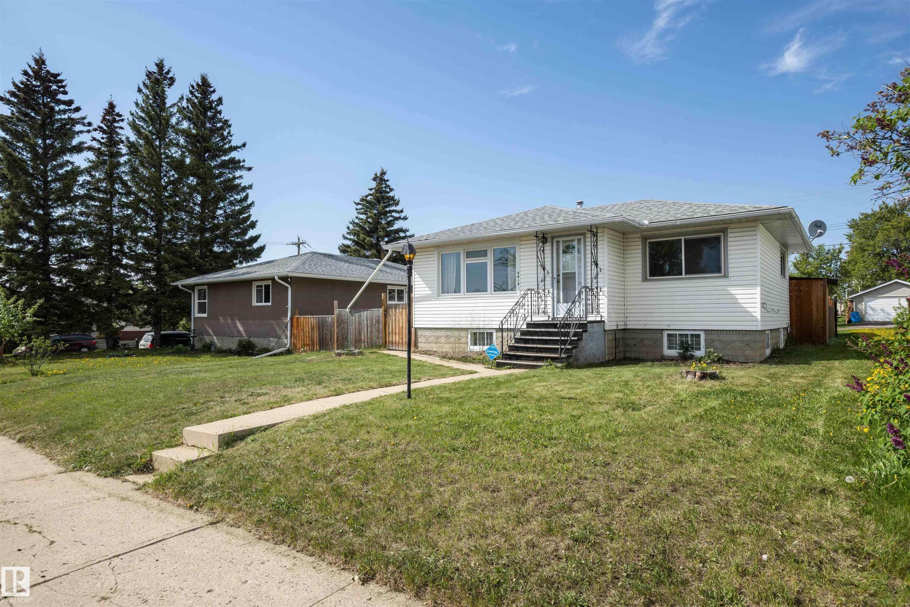 Front elevation featuring white siding and a light gray shingle roof - 4414 54 Avenue, Barrhead, AB - Outdoor
