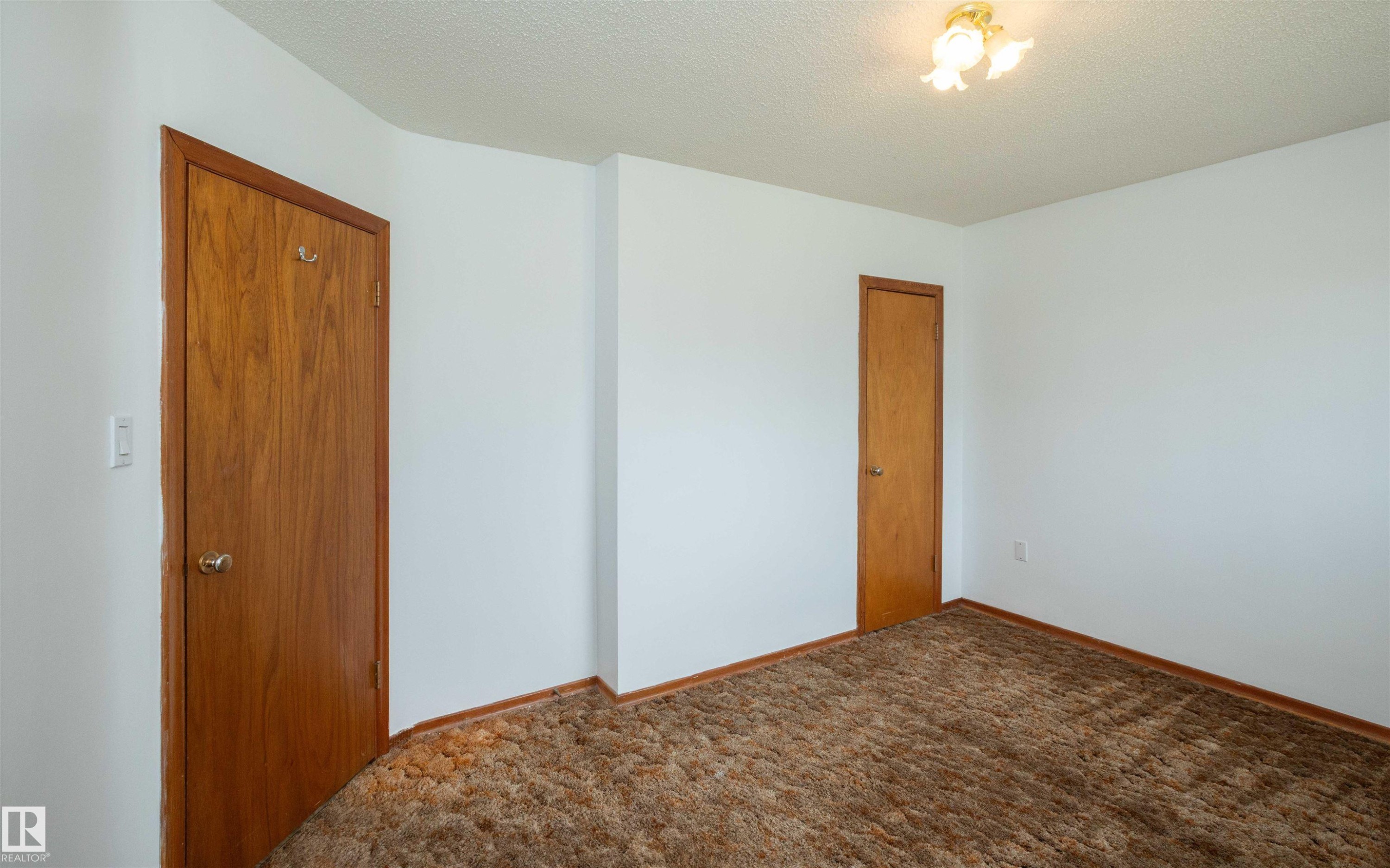 Neutral-toned walls complement the textured brown carpeting - 4414 54 Avenue, Barrhead, AB - Indoor Photo Showing Other Room