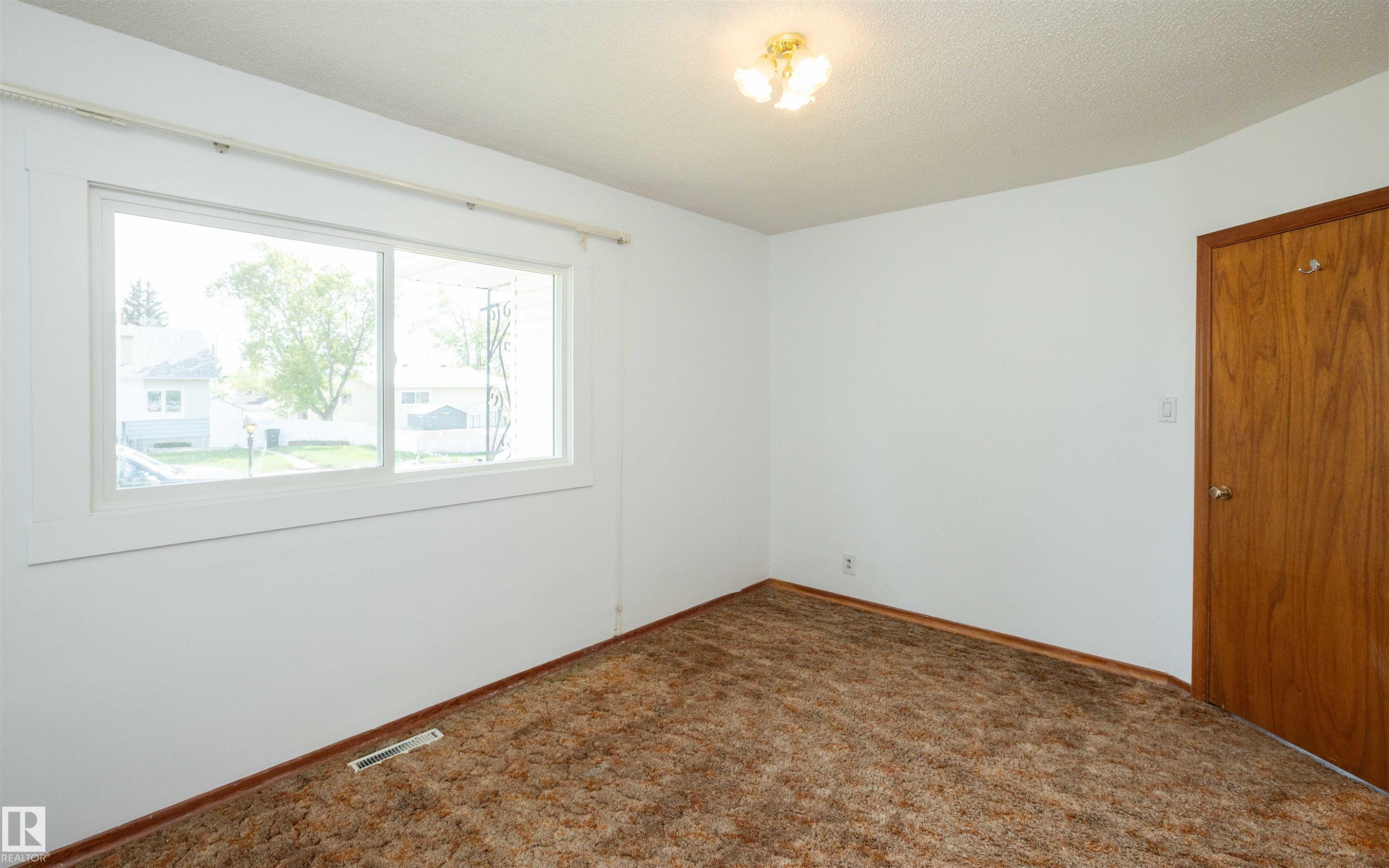 Interior room with white painted walls, textured ceiling, and a large window - 4414 54 Avenue, Barrhead, AB - Indoor Photo Showing Other Room
