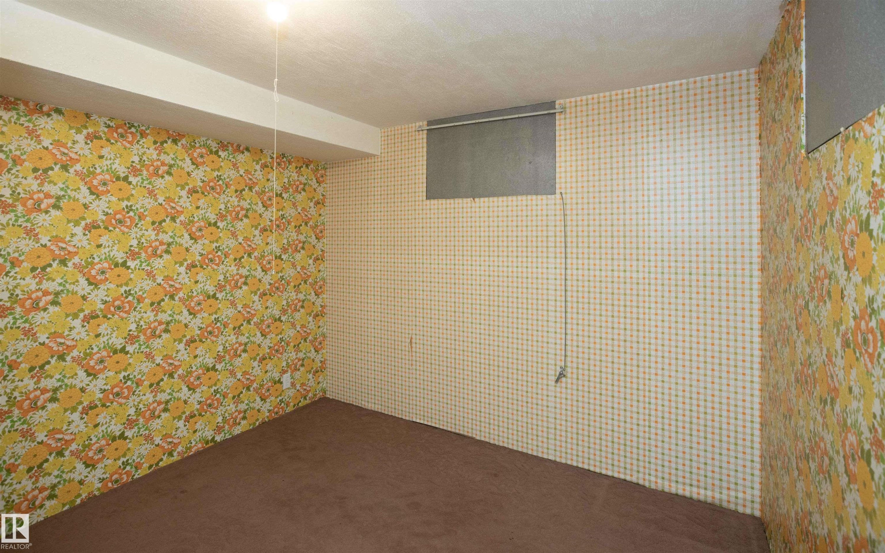 Lower level room featuring patterned wallpaper, carpet flooring, a drop ceiling, and a recessed window - 4414 54 Avenue, Barrhead, AB - Indoor Photo Showing Other Room