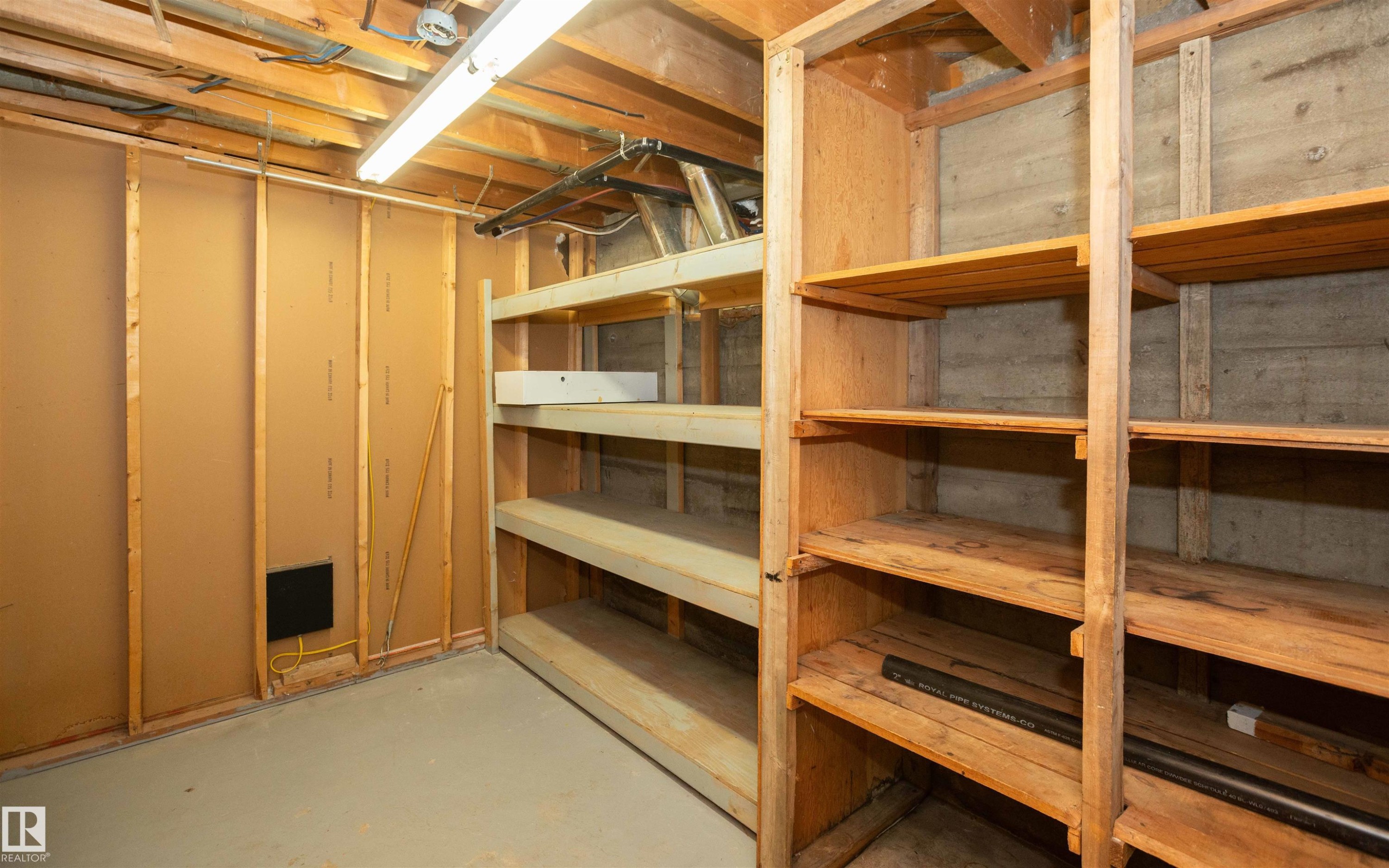 Extensive built-in wood shelving units provide ample storage capacity within this unfinished space - 4414 54 Avenue, Barrhead, AB - Indoor Photo Showing Basement