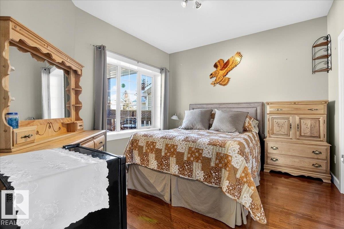 Hardwood-finish flooring complements light-toned walls - 5019 48 Avenue, Chipman, AB - Indoor Photo Showing Bedroom