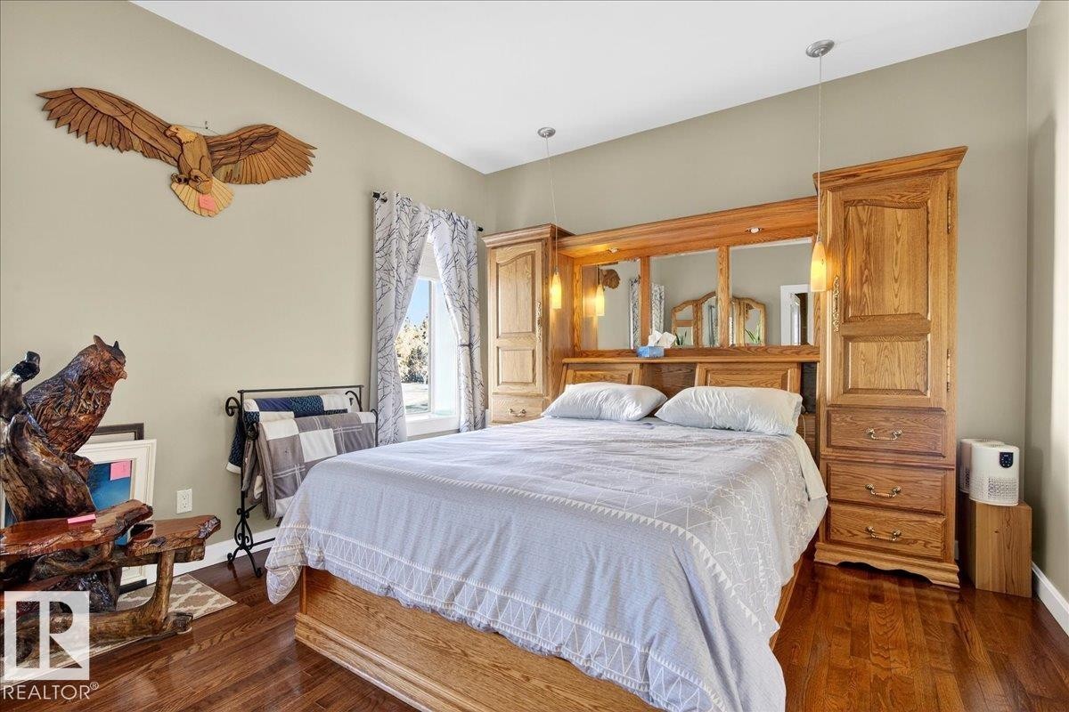 Hardwood flooring complements a neutral wall color - 5019 48 Avenue, Chipman, AB - Indoor Photo Showing Bedroom